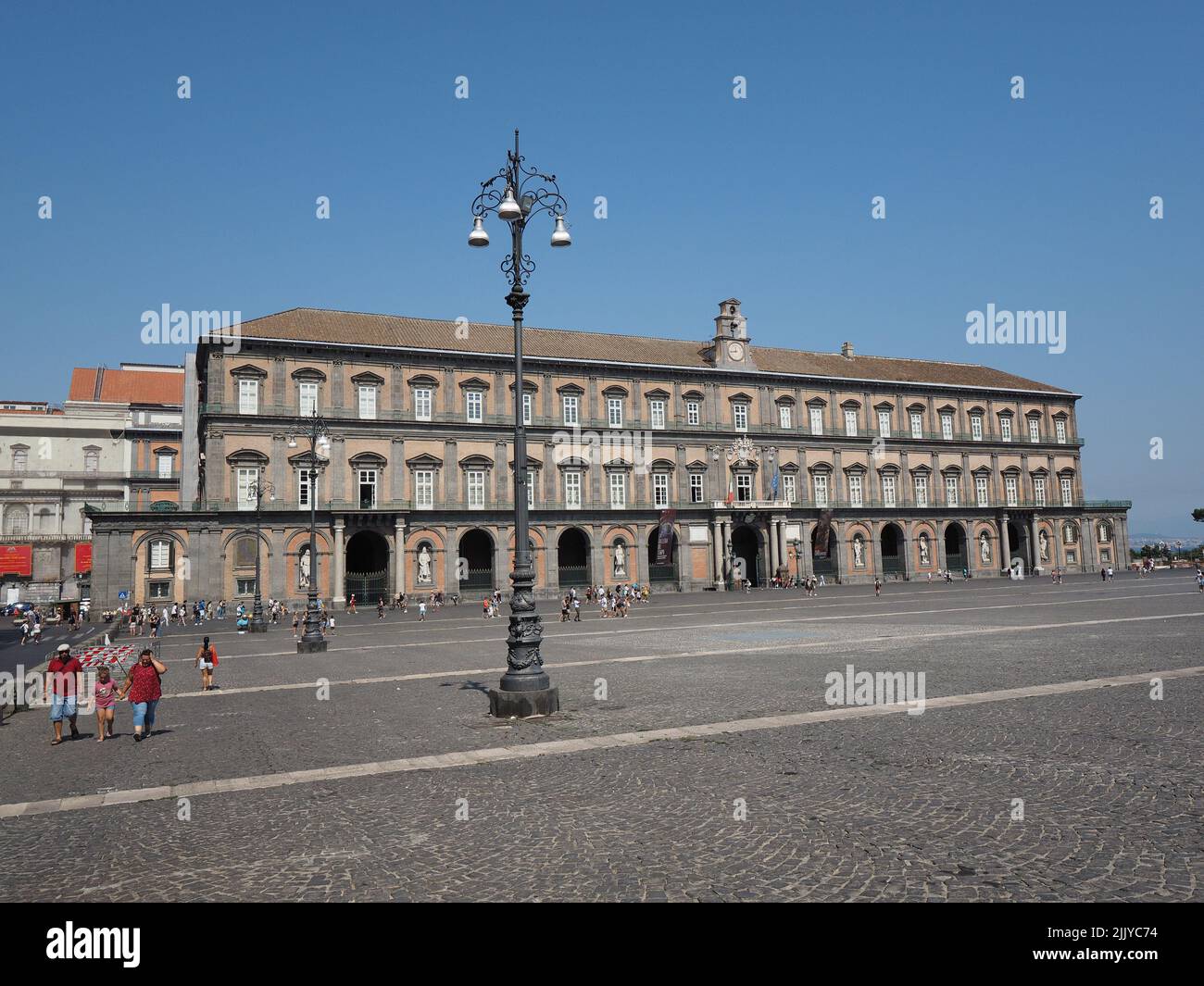 Front facade of the Palazzo Reale, or Royal Palace, in the city center of Naples, Campania, Italy. The facade is decorated with large statues of the k Stock Photo