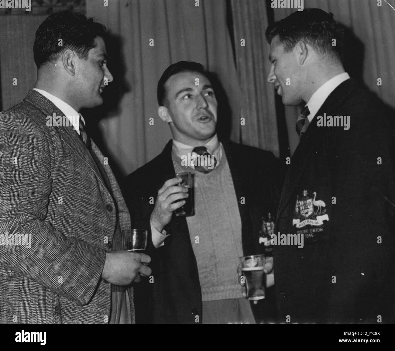 Over Drinks, Don Eurness (centre), who unluckily missed selection for England, whishes luck to Randwick Clubmates, Nick Shehadie (left) and Arthur Buchan. July 19, 1947. Stock Photo
