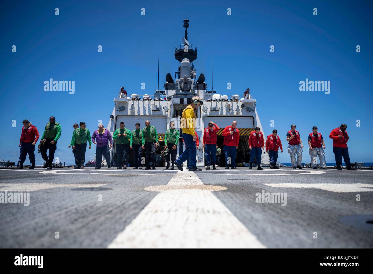 July 14, 2022 - At Sea - Members of the U.S. Coast Guard Cutter Midgett and U.S Navy check the flight deck for debris prior to flight operations in the Pacific Ocean, July 12, 2022. Twenty-six nations, 38 ships, four submarines, more than 170 aircraft and 25,000 personnel are participating in RIMPAC from June 29 to Aug. 4 in and around the Hawaiian Islands and Southern California. The worlds largest international maritime exercise, RIMPAC provides a unique training opportunity while fostering and sustaining cooperative relationships among participants critical to ensuring the safety of sea lan Stock Photo