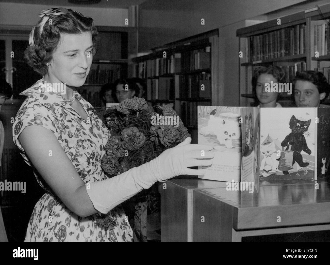 Royal Visitor - Princess Alexandra, daughter of the Duchess of Kent, seen looking at some French 'Fairy Tale Books' in the Library of the new wing of the Royal foundation of Greycoat hospital, Westminister, today which the Princess opened. The hospital is now used as a girls school. July 18, 1955. (Photo by Paul Popper, Paul Popper Ltd.). Stock Photo