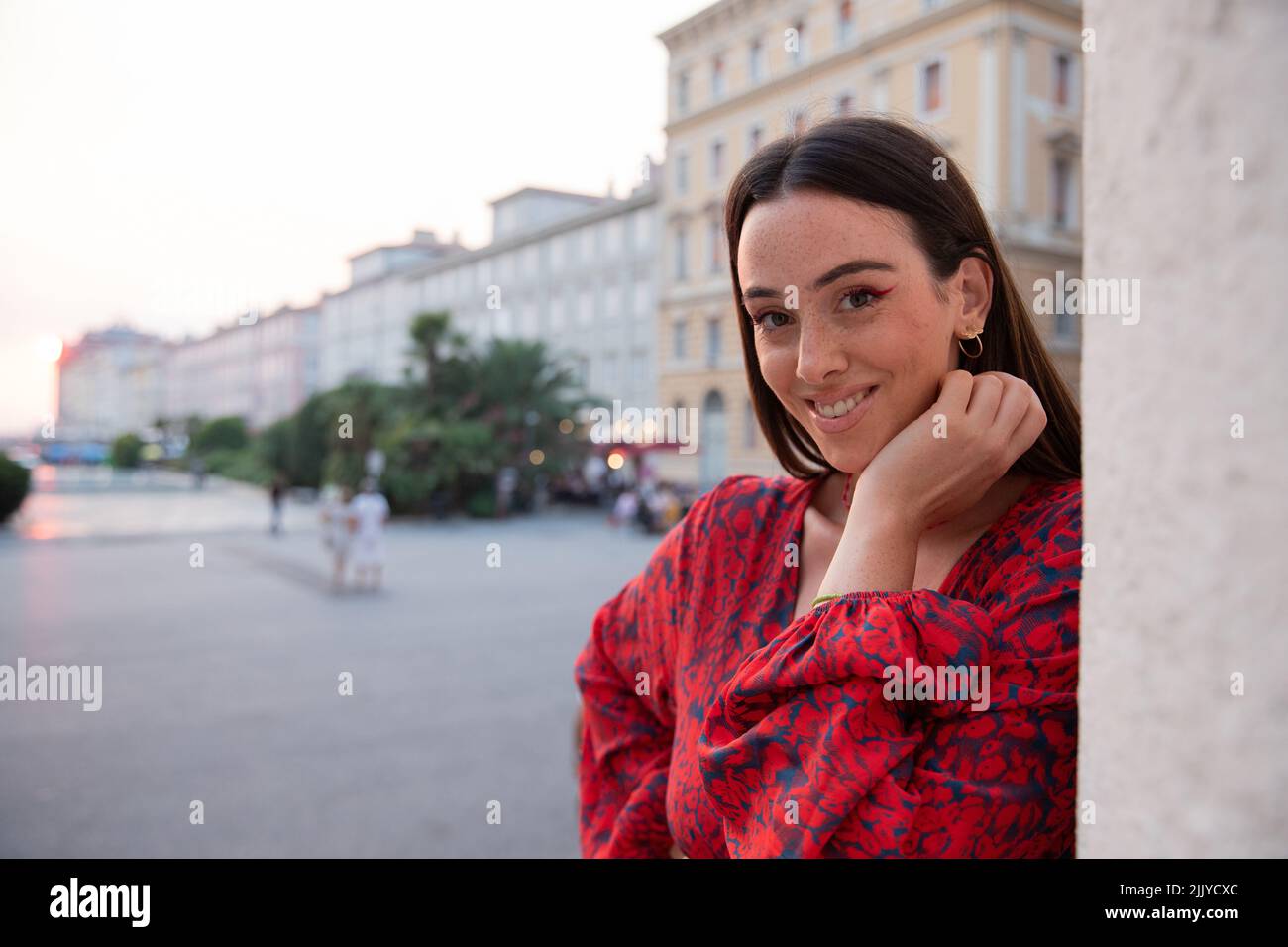 Portrait of a smiling woman on vacation in italy during sunset, happy caucasian girl Stock Photo