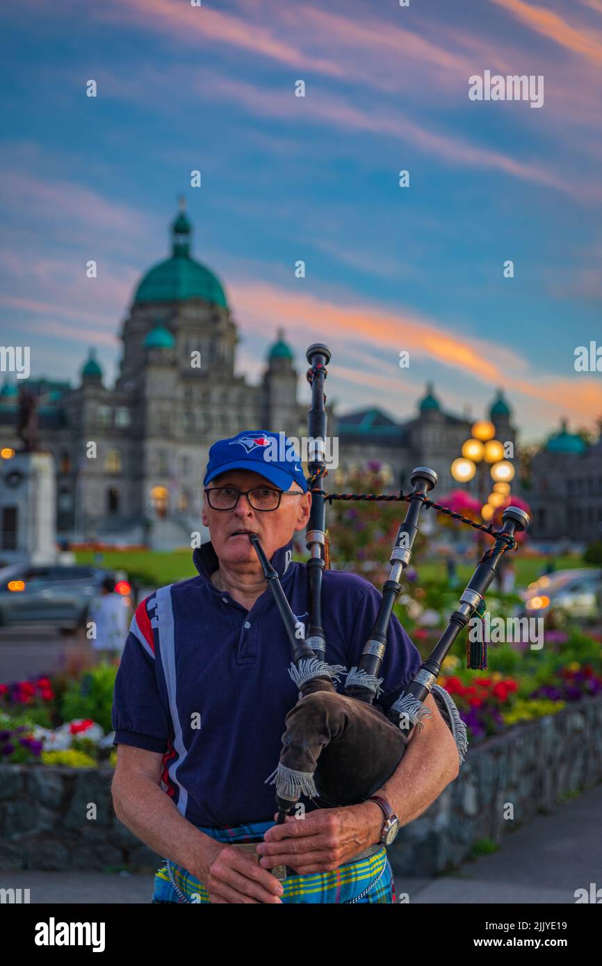 Bagpiper in Victoria BC. Scottish bagpiper dressed in traditional tartan dress playing bagpipers-July 20,2022-Canada-Travel photo, street view Stock Photo