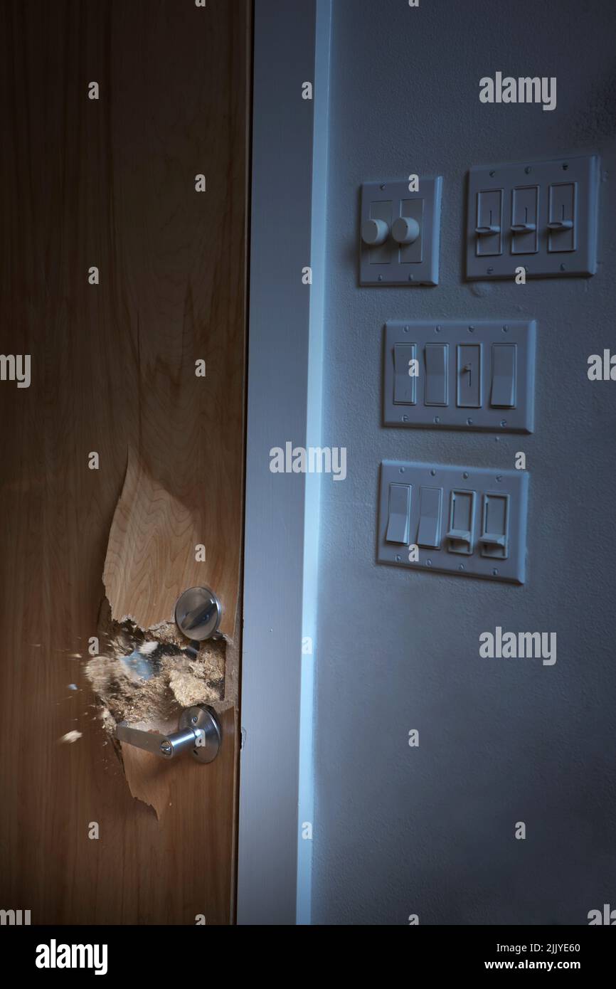 Residential door being smashed with sledgehammer in home invasion Stock Photo