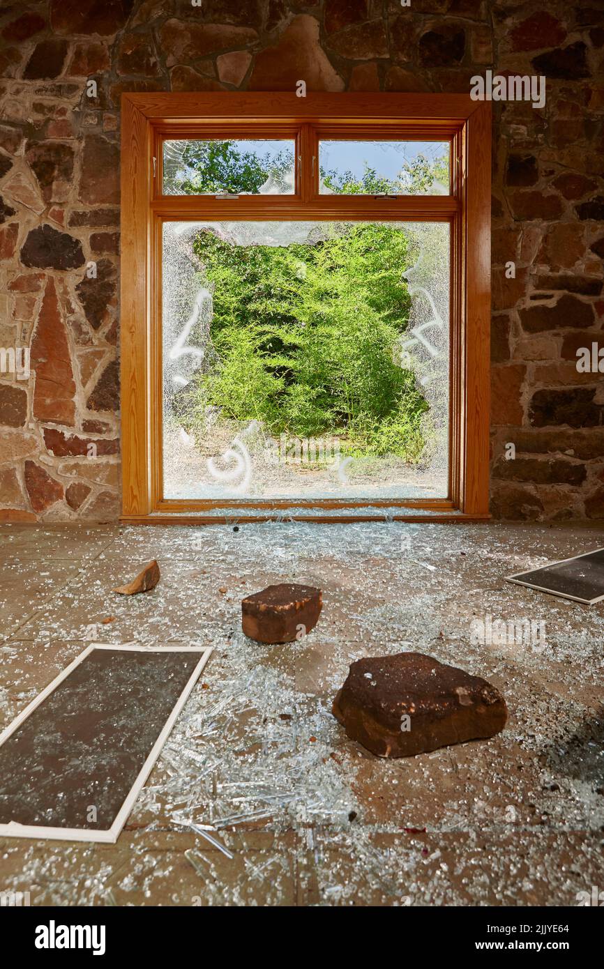 Home Invasion, Smashed and shattered window in a residential home Stock Photo