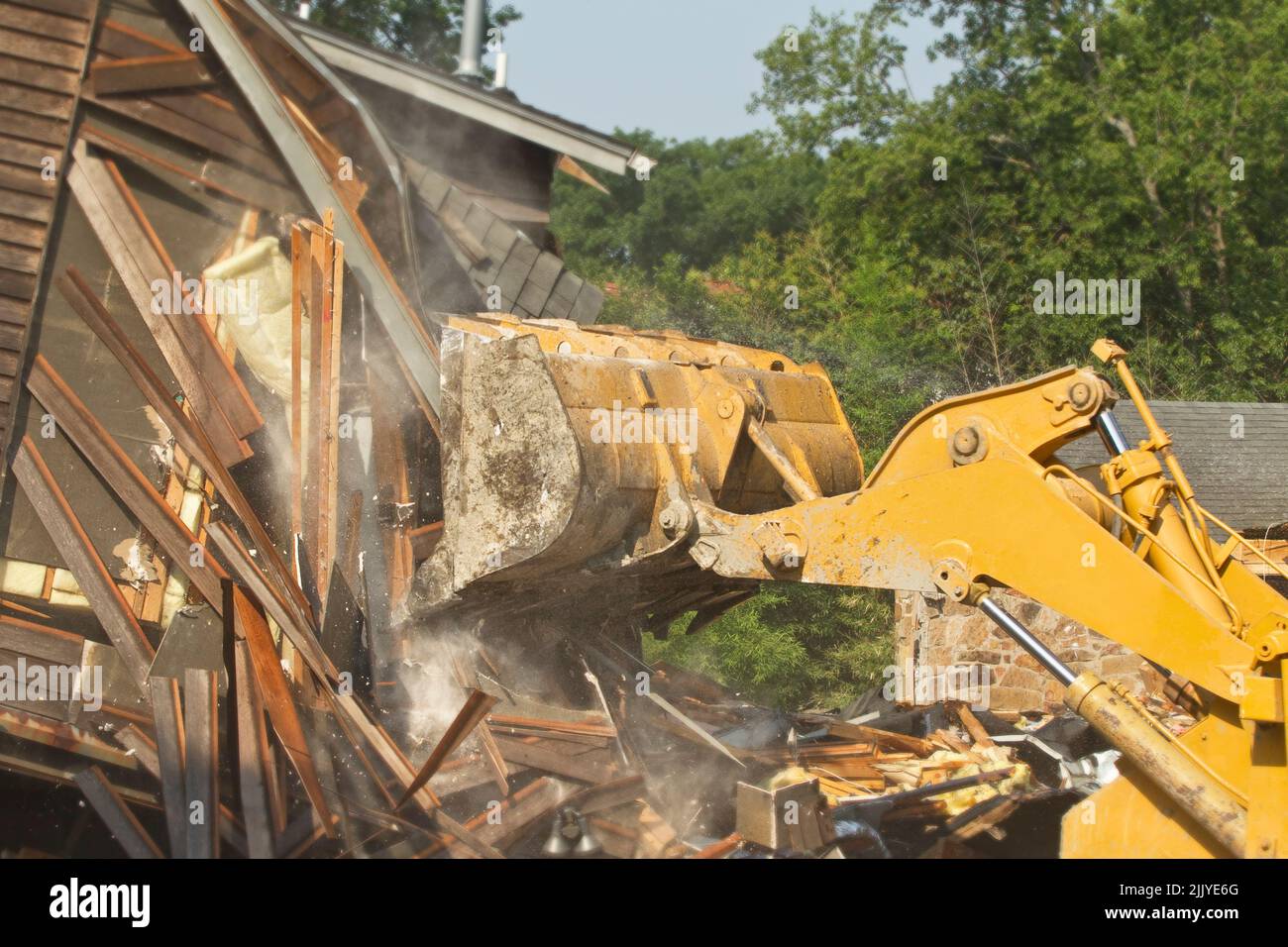 Demolition of residential home with bulldozer preparing for new construction Stock Photo