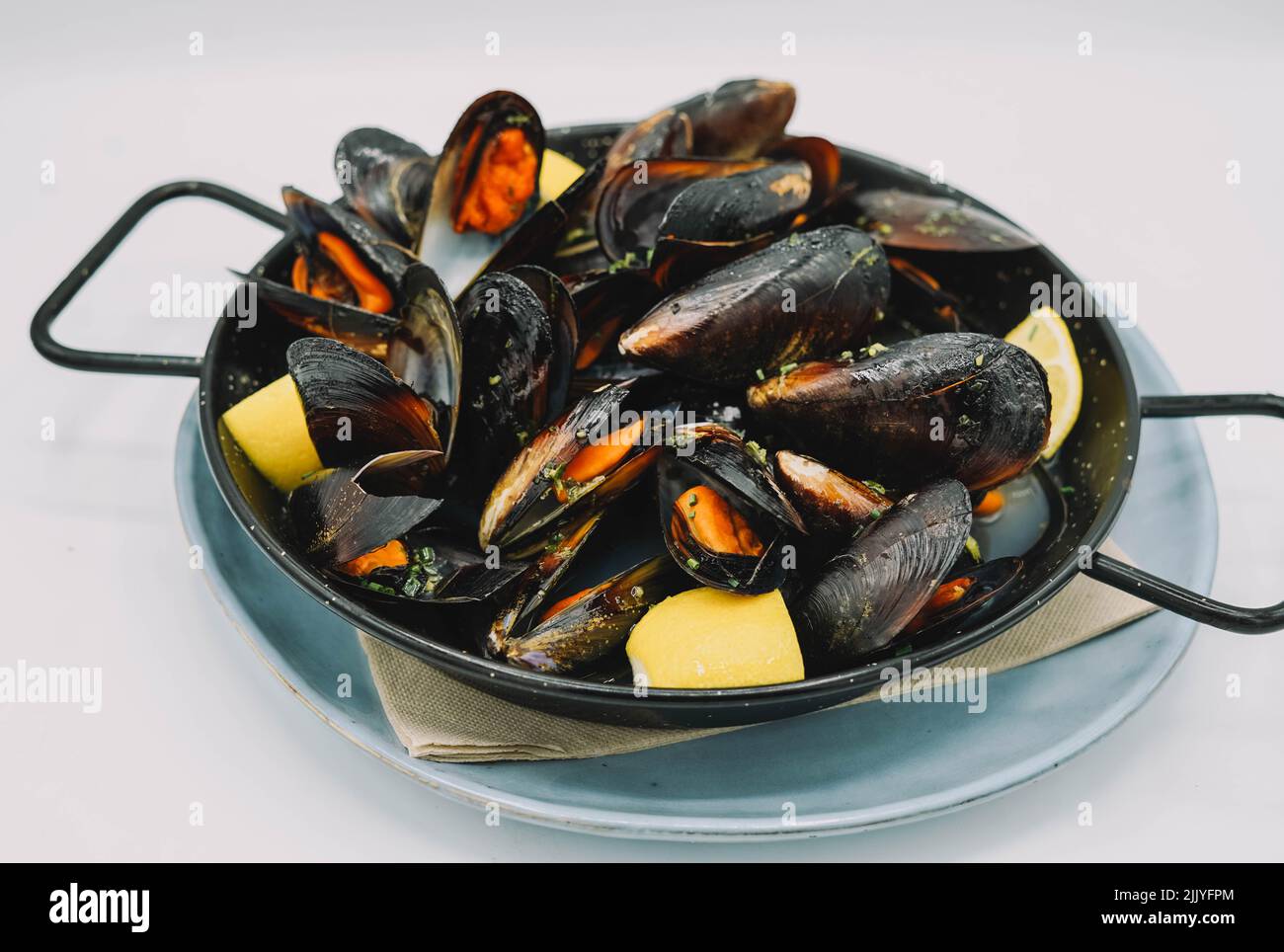 A portion of steamed mussels with garlic and parsley Stock Photo