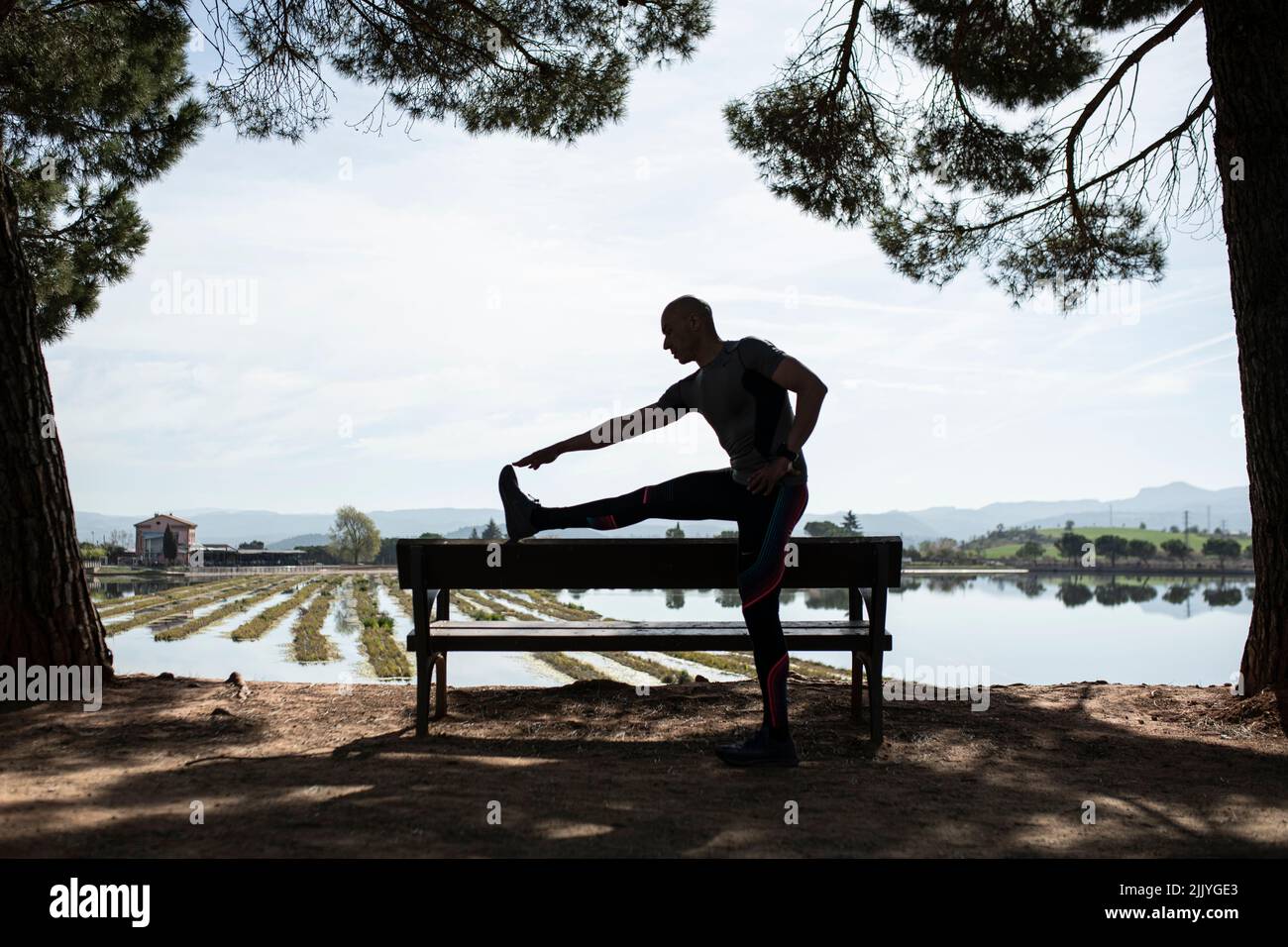 Silhouette of man doing stretching exercise Stock Photo