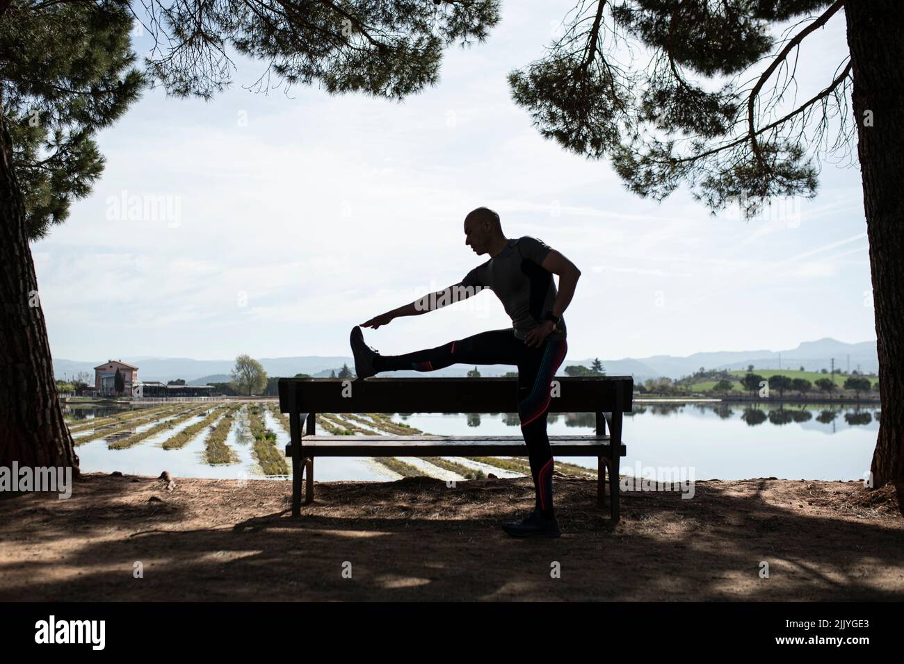 Silhouette of man doing stretching exercise Stock Photo - Alamy