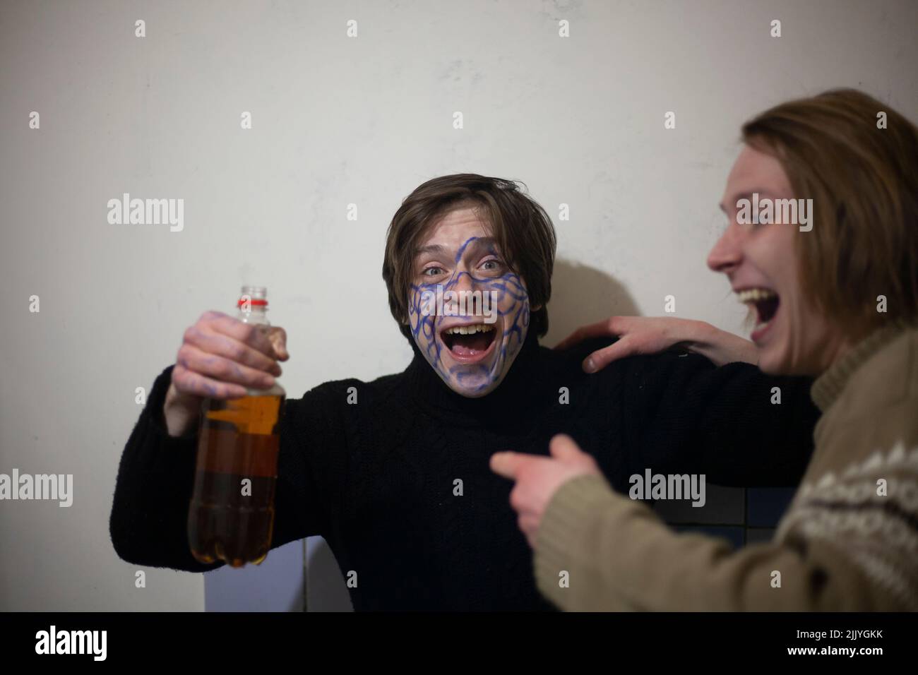 Guys drink alcohol at a party. Crazy guys having fun with beer. Stock Photo