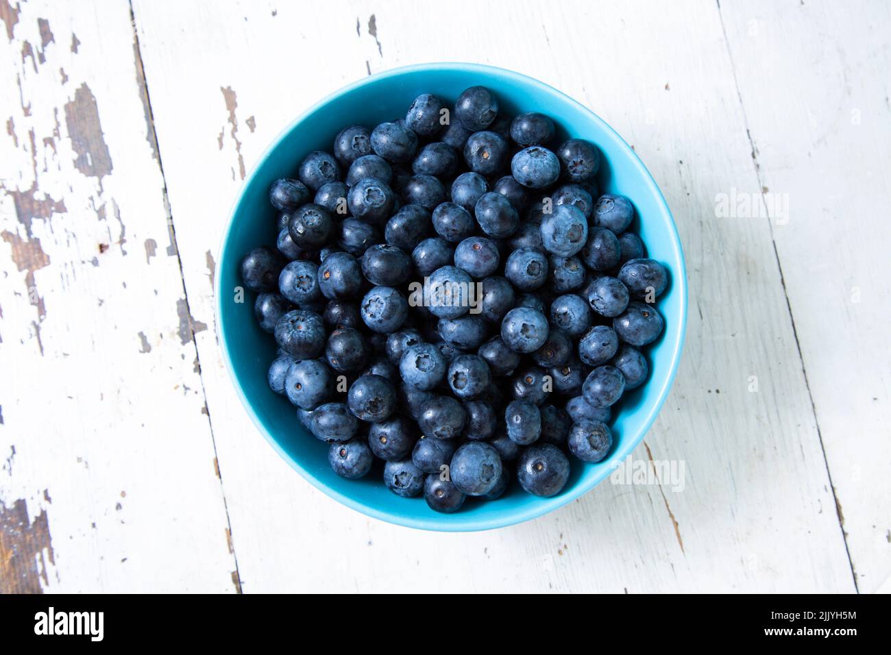 Top view of round bowl with blueberries on wooden table Stock Photo