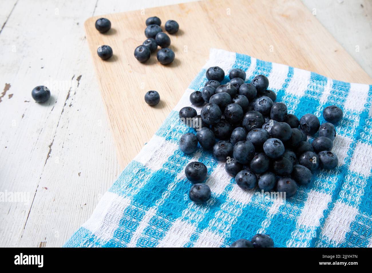 Blueberries on a napkin with a checkered pattern on a wooden table Stock Photo