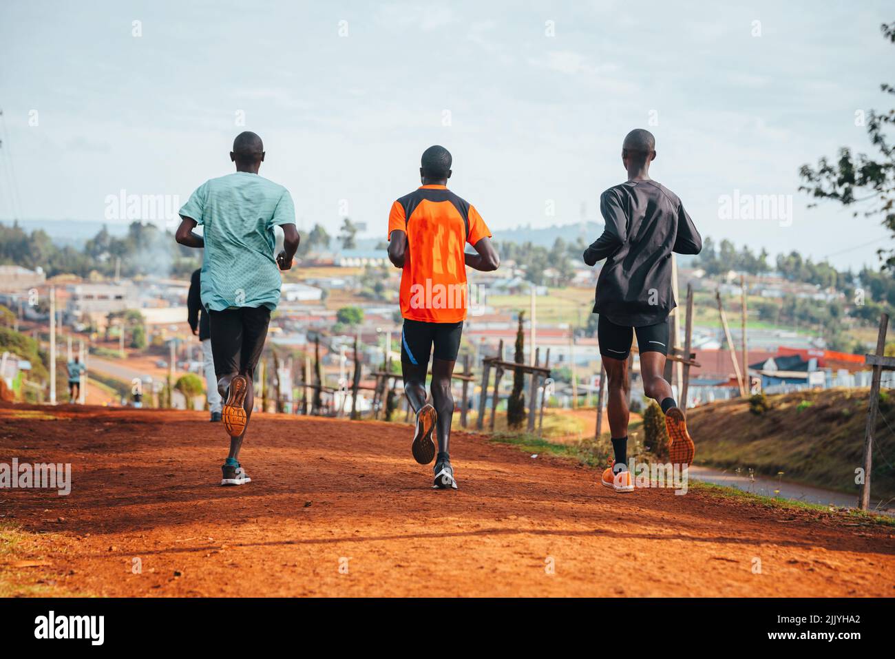 Morning running training. in Kenya. Marathon runners on red soil train in the light of the rising sun. Motivation to move. Endurance running, athletic Stock Photo