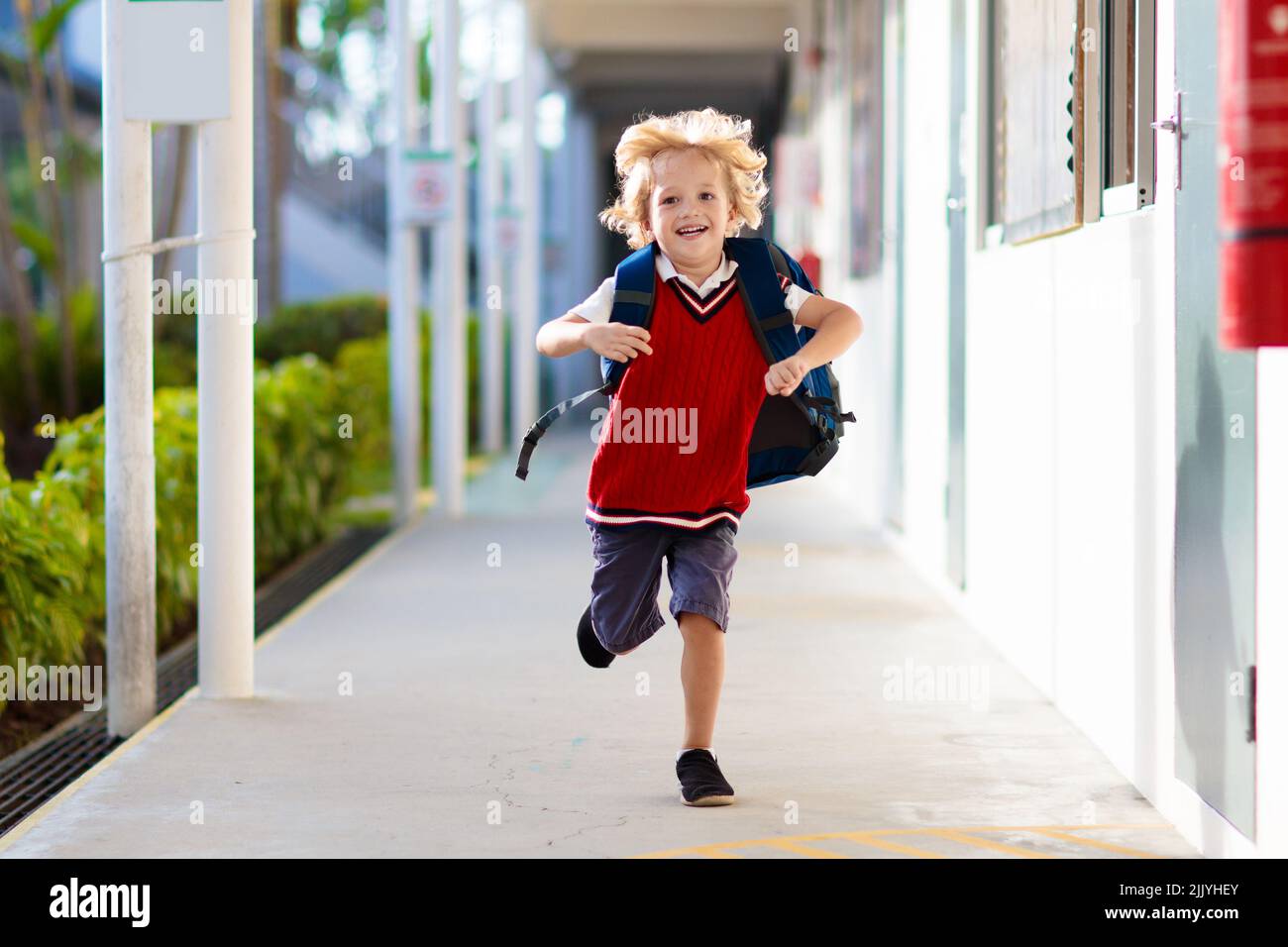 Child going to school. Boy running in school yard. Little student