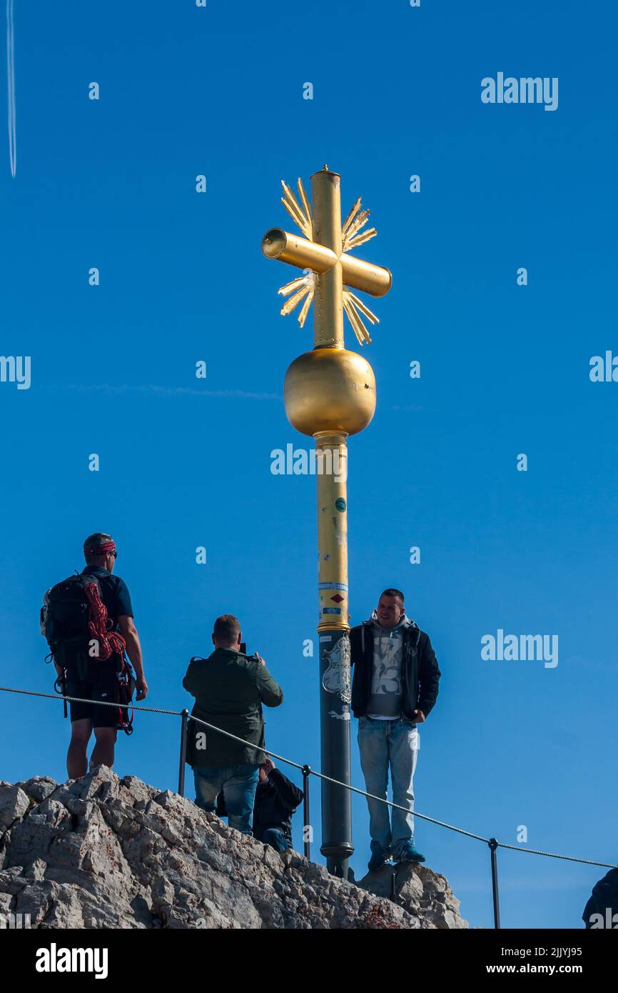 Visitors at Golden summit cross, Zugspitze, the peak of Germany and Wetterstein Mountains near Garmisch-Partenkirchen Stock Photo