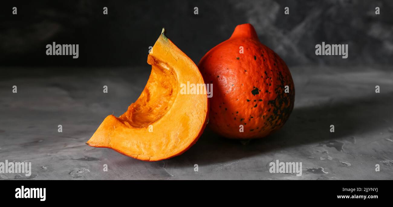 Fresh pumpkin with piece on dark background Stock Photo - Alamy