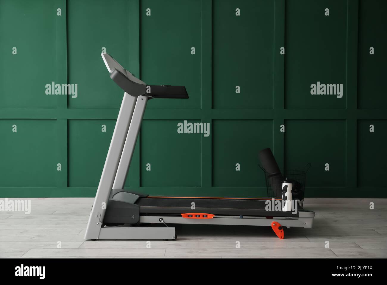 Modern treadmill near green wall Stock Photo - Alamy