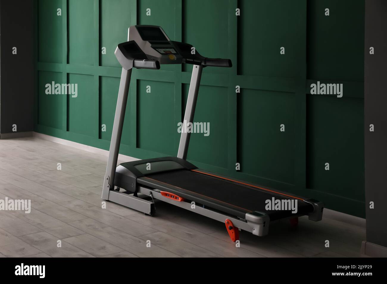 Modern treadmill near green wall Stock Photo - Alamy