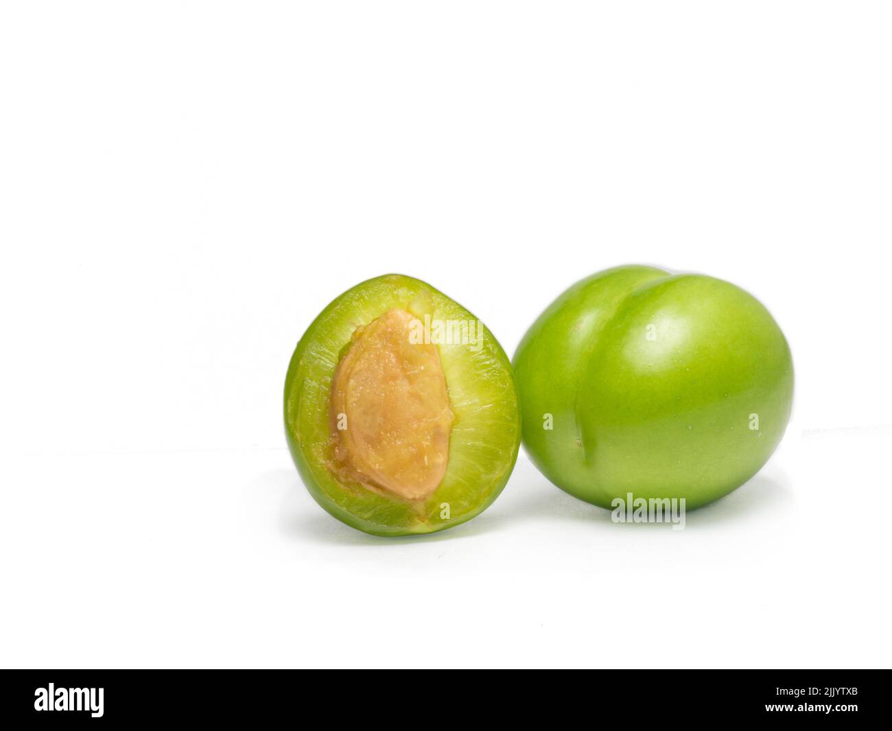 Green cherry plum on a white background. Fruit for making tkemali sauce ...