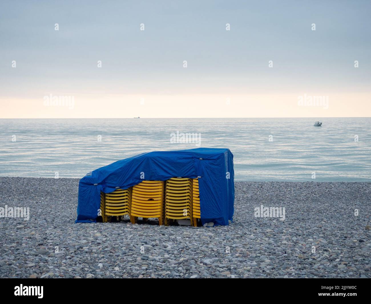Stacked plastic sun loungers on the beach. Sunbeds in bad weather