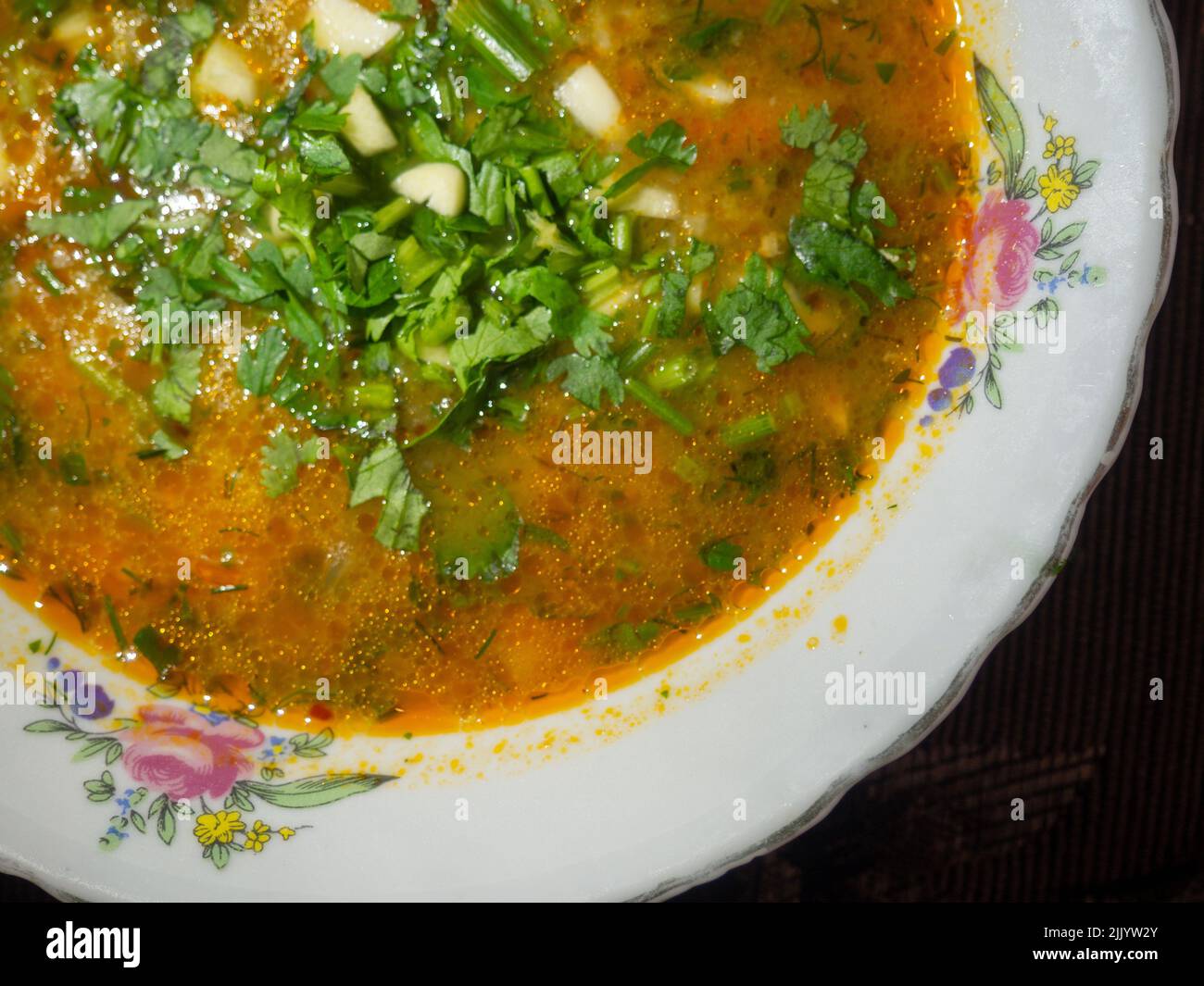 Red soup sprinkled with herbs. Lunch is on the table. First course