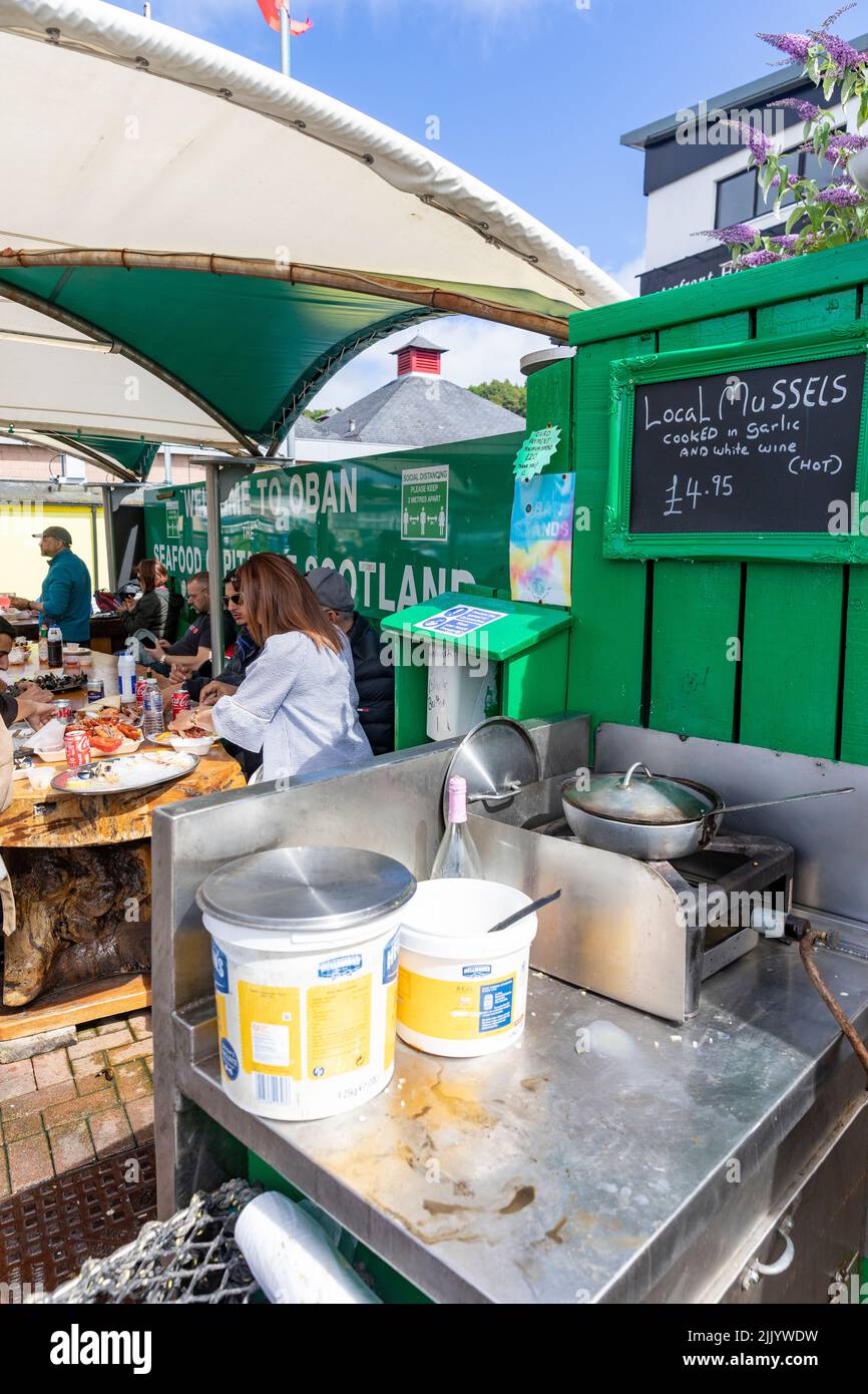 Customers buying fresh seafood and shellfish at Oban port, mussels ...