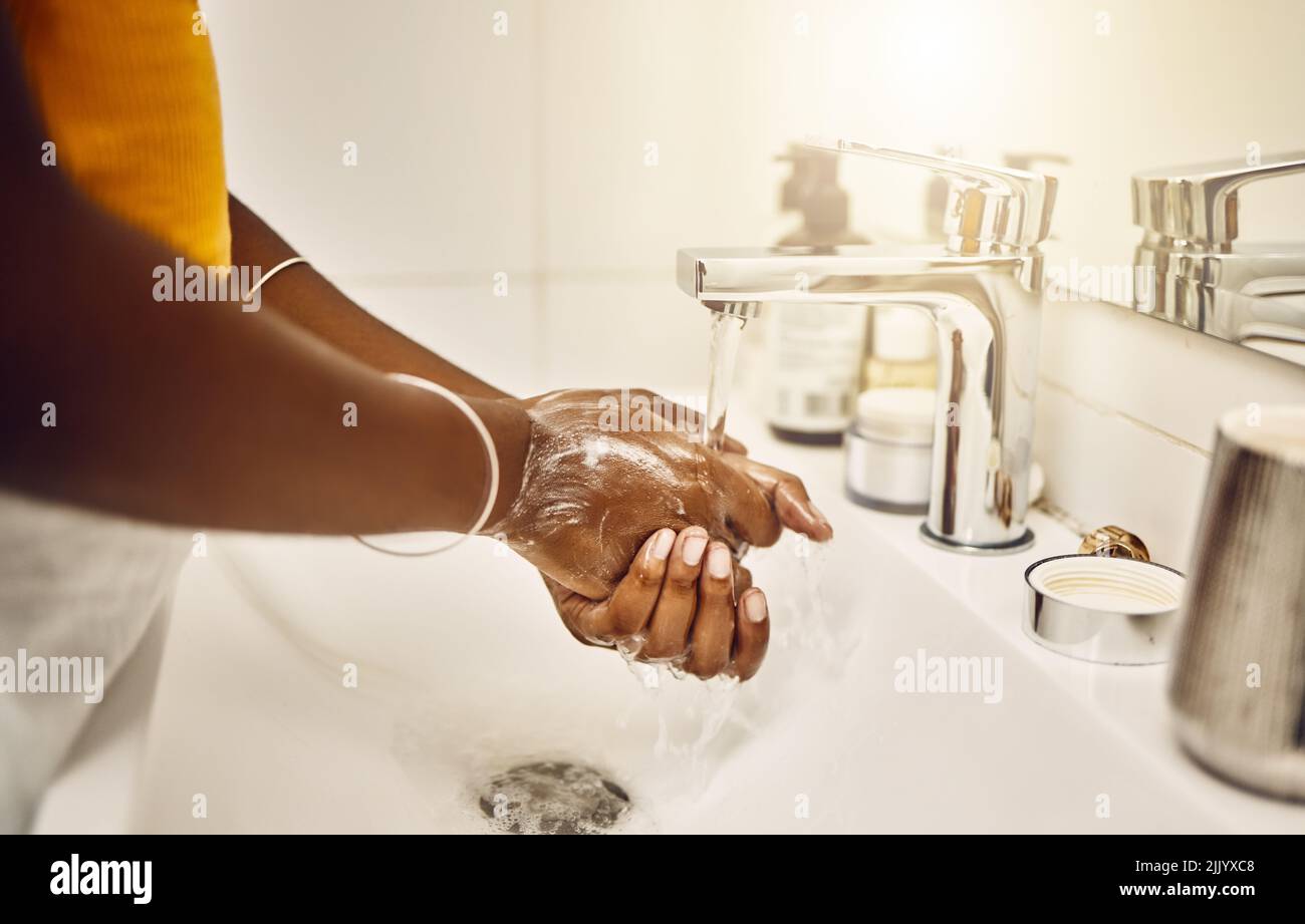 Washing, cleaning and keeping hands clean with water and soap in the bathroom to protect, keep safe and lower risk of getting sickness, illness or Stock Photo