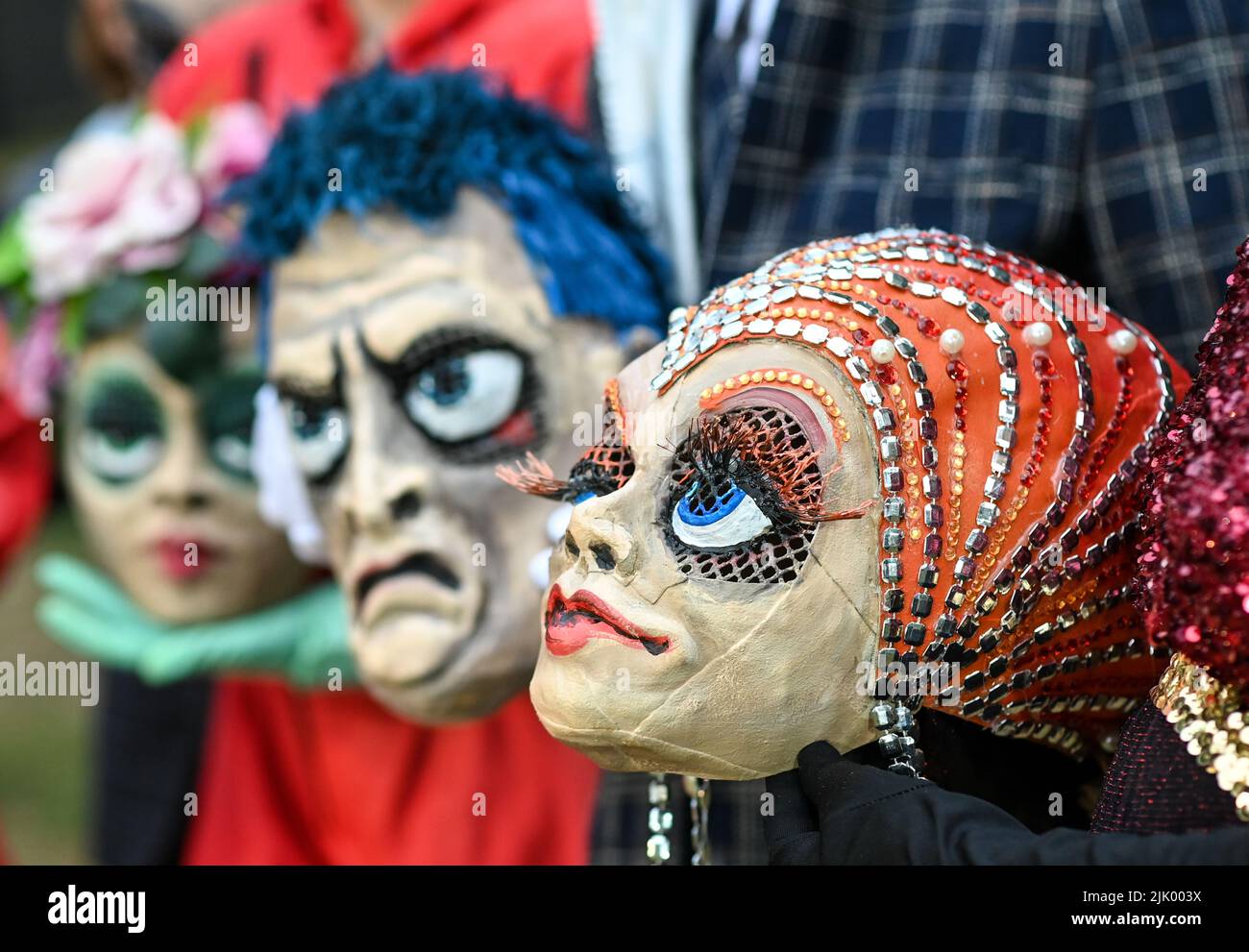 Netzeband, Germany. 25th July, 2022. Performers hold their masks before a rehearsal of the play 'Metropolis' at the Theater Sommer Netzeband. The famous film by Fritz Lang and the novel of the same name will be staged open air with 28 actors in the look of the 20s with special costumes. Performances are after the premiere on July 29 always on Fridays and Saturdays until August 27. Credit: Jens Kalaene/dpa/Alamy Live News Stock Photo