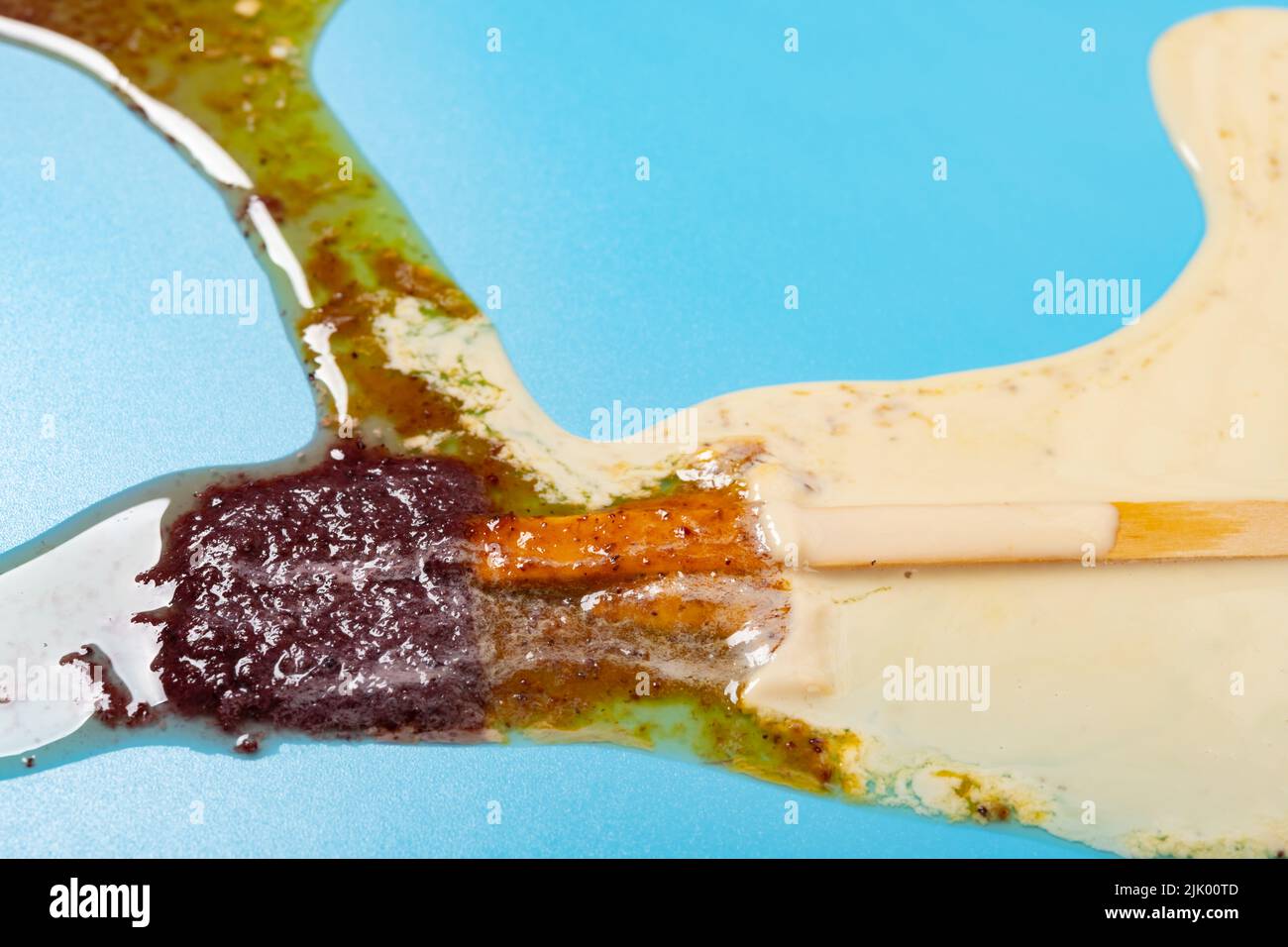 passion fruit and waxberry and milkshake flavor popsicle melted on blue background Stock Photo