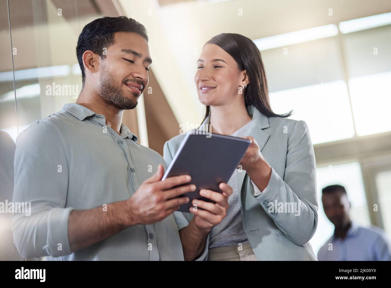 What do you think about my plan. two coworkers talking while using a digital tablet. Stock Photo