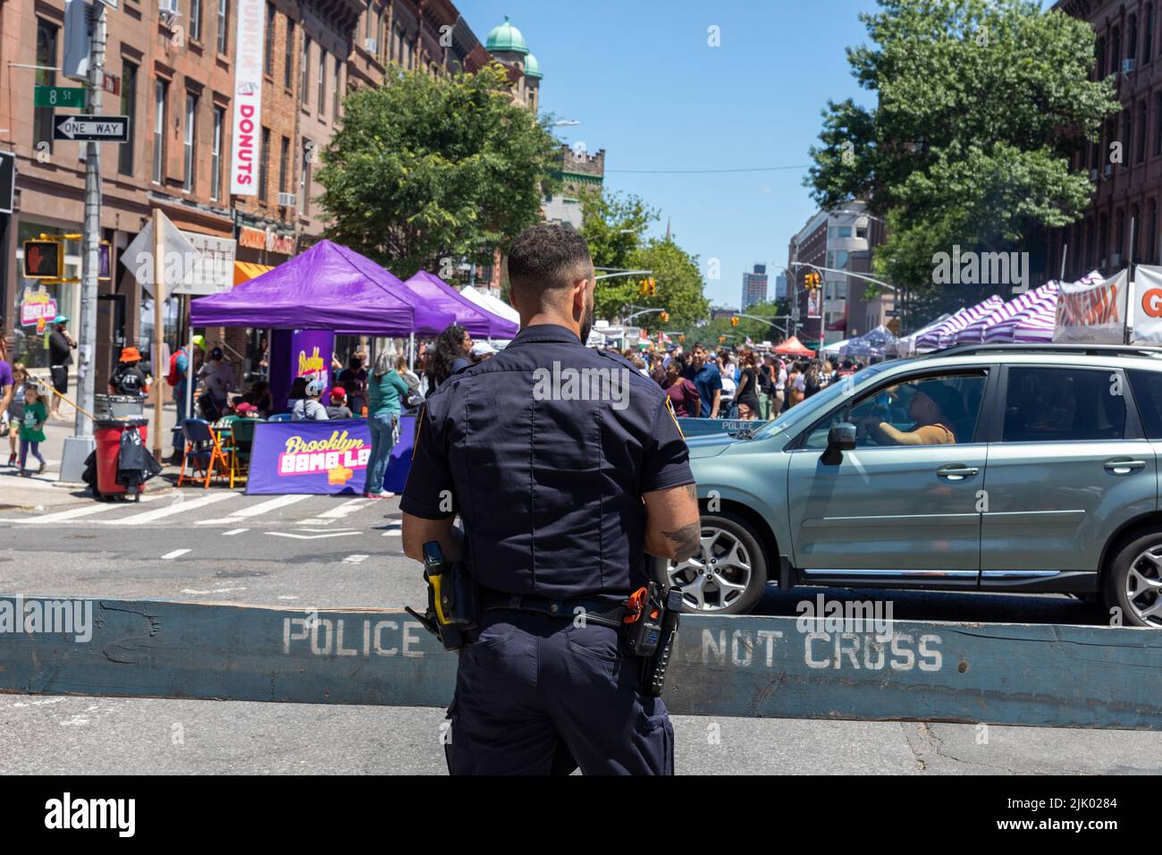 A police officer on duty at Father's Day at a street fair in 7th Ave