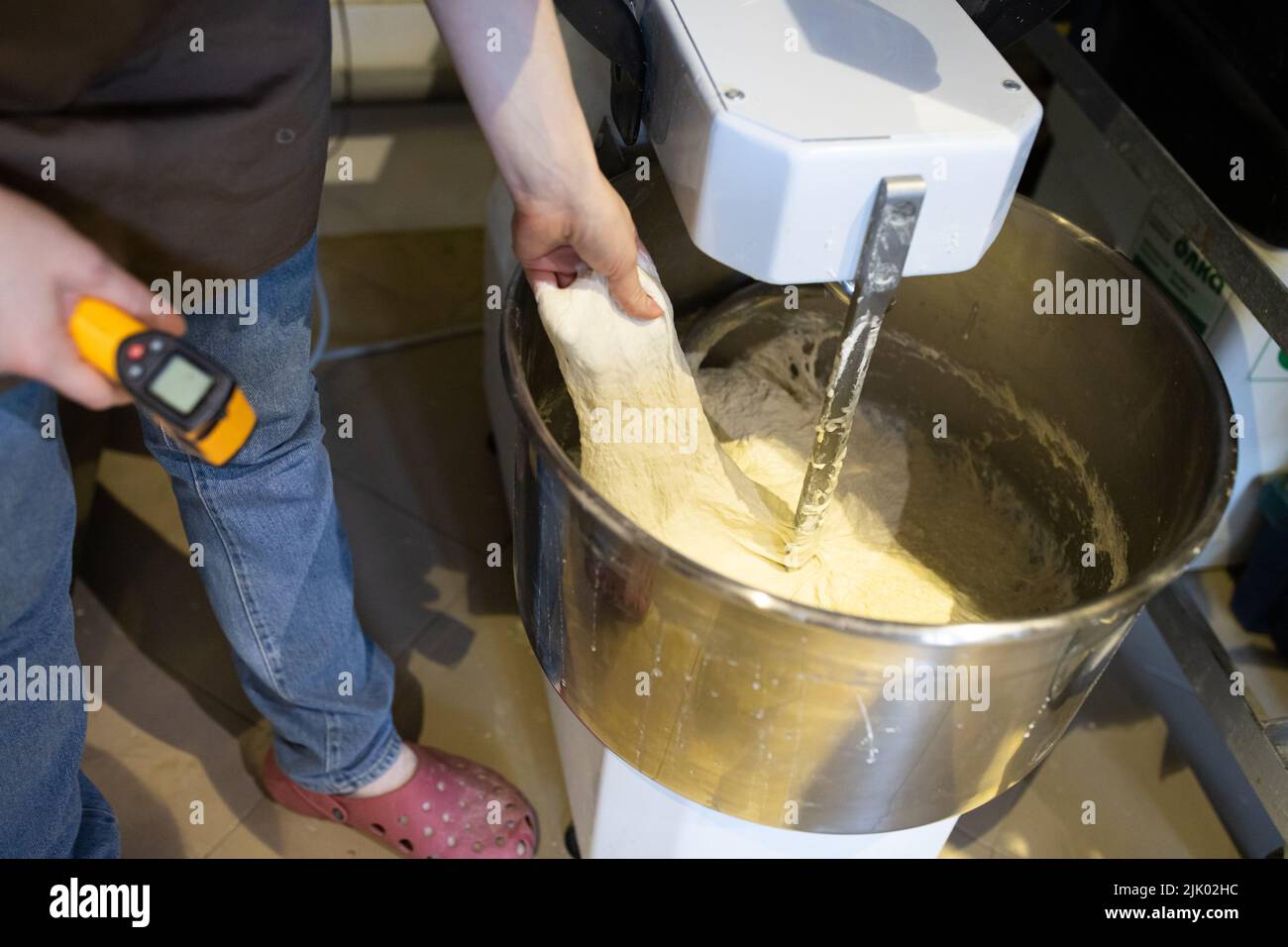 https://c8.alamy.com/comp/2JK02HC/the-baker-kneads-bread-in-a-dough-mixer-the-process-of-making-bread-in-an-artisan-bakery-measuring-the-temperature-of-the-dough-front-view-2JK02HC.jpg