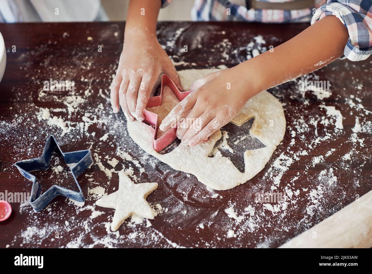 One for mom too. an unrecognizable girl using a cookie cutter while