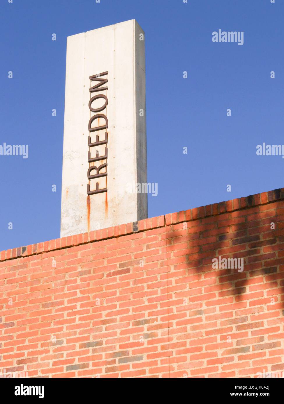 Word freedom vertically aligned on sign against blue sky Stock Photo ...