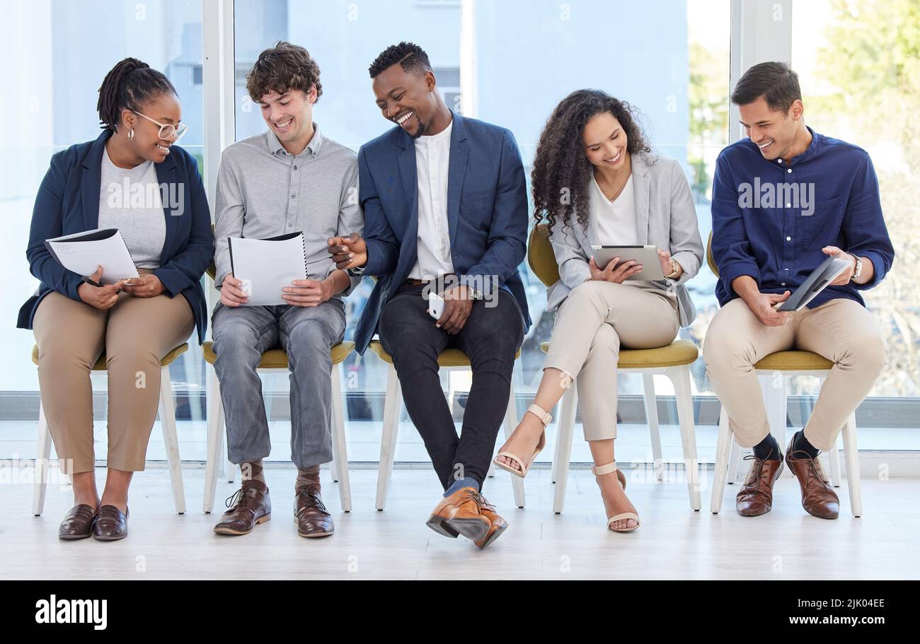 Staying well-prepared for anything that comes their way. a group of businesspeople sitting in line in an office. Stock Photo