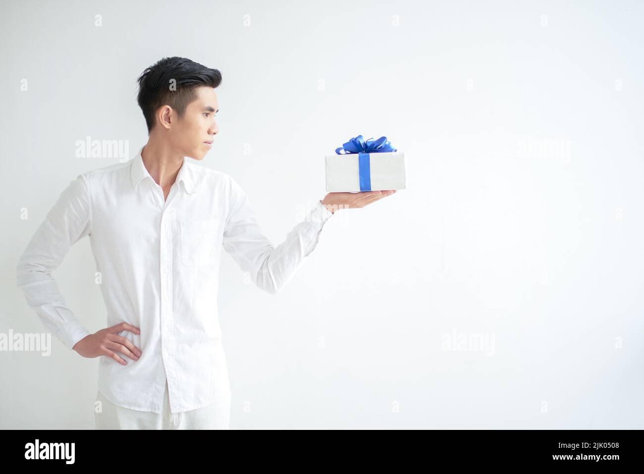 Young Asian man looking at gift on his hand, isolated on white Stock Photo