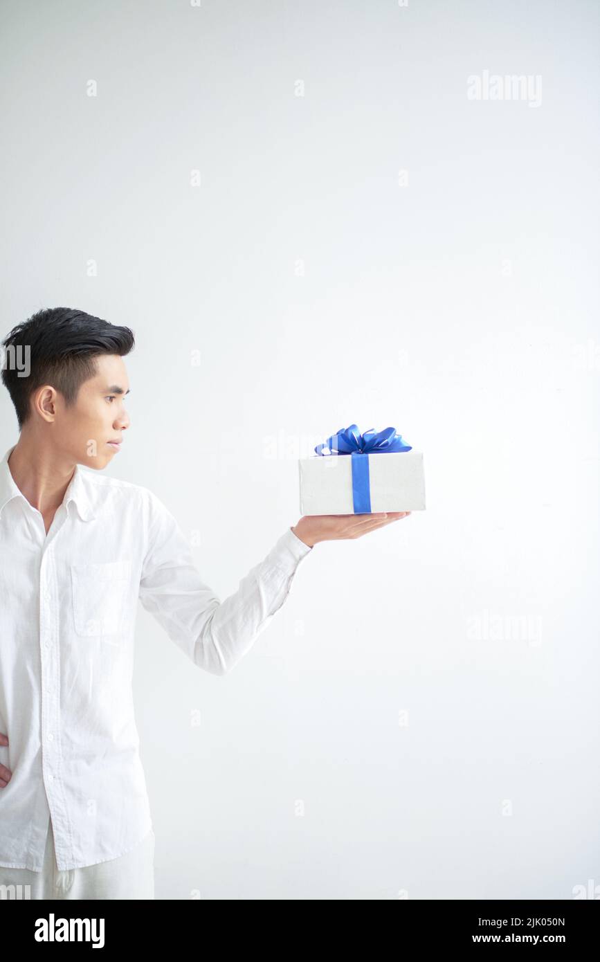Vietnamese young man looking at giftbox on his hand Stock Photo