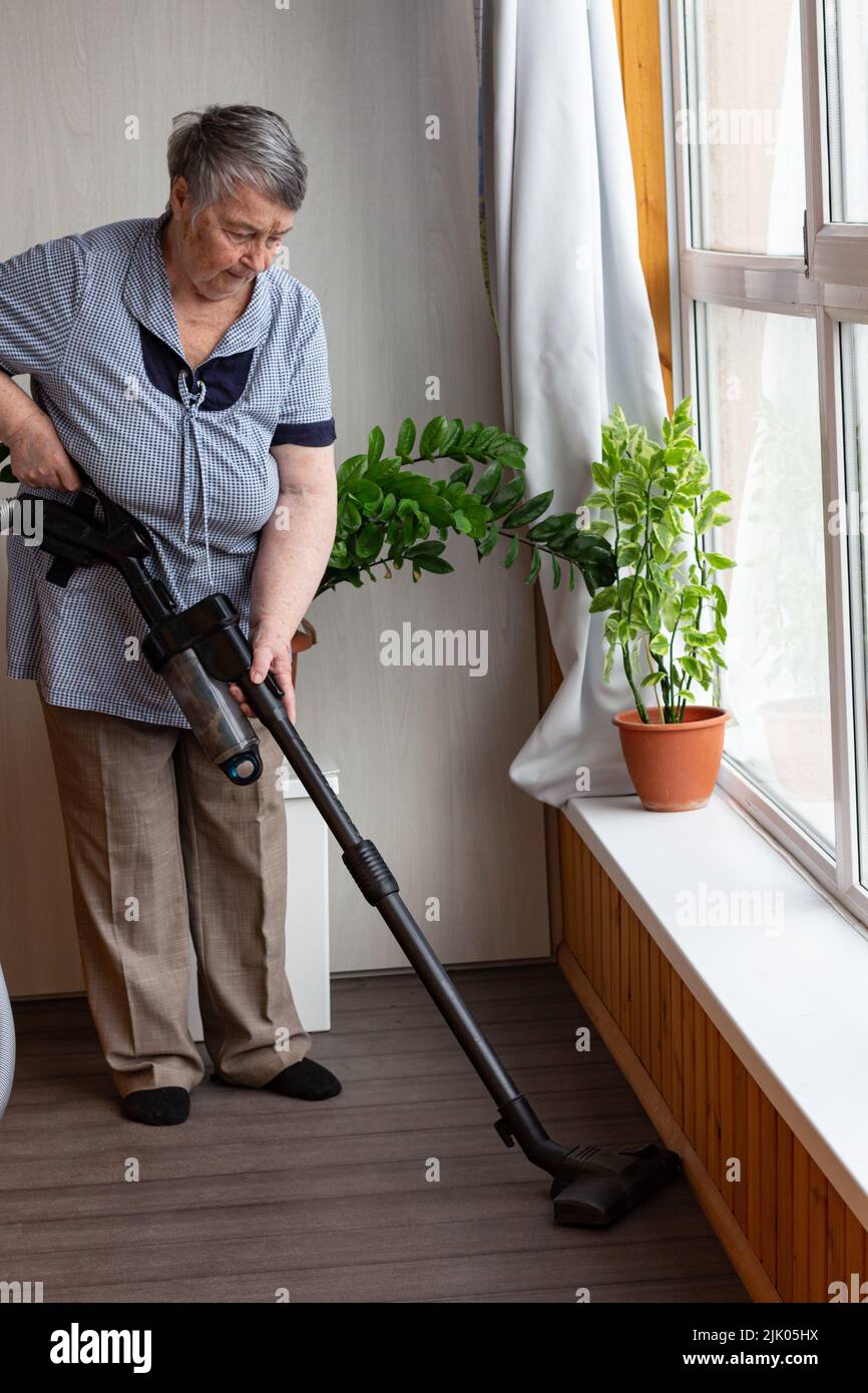 Woman With A Child Cleaning With A Vacuum Cleaner Stock Photo