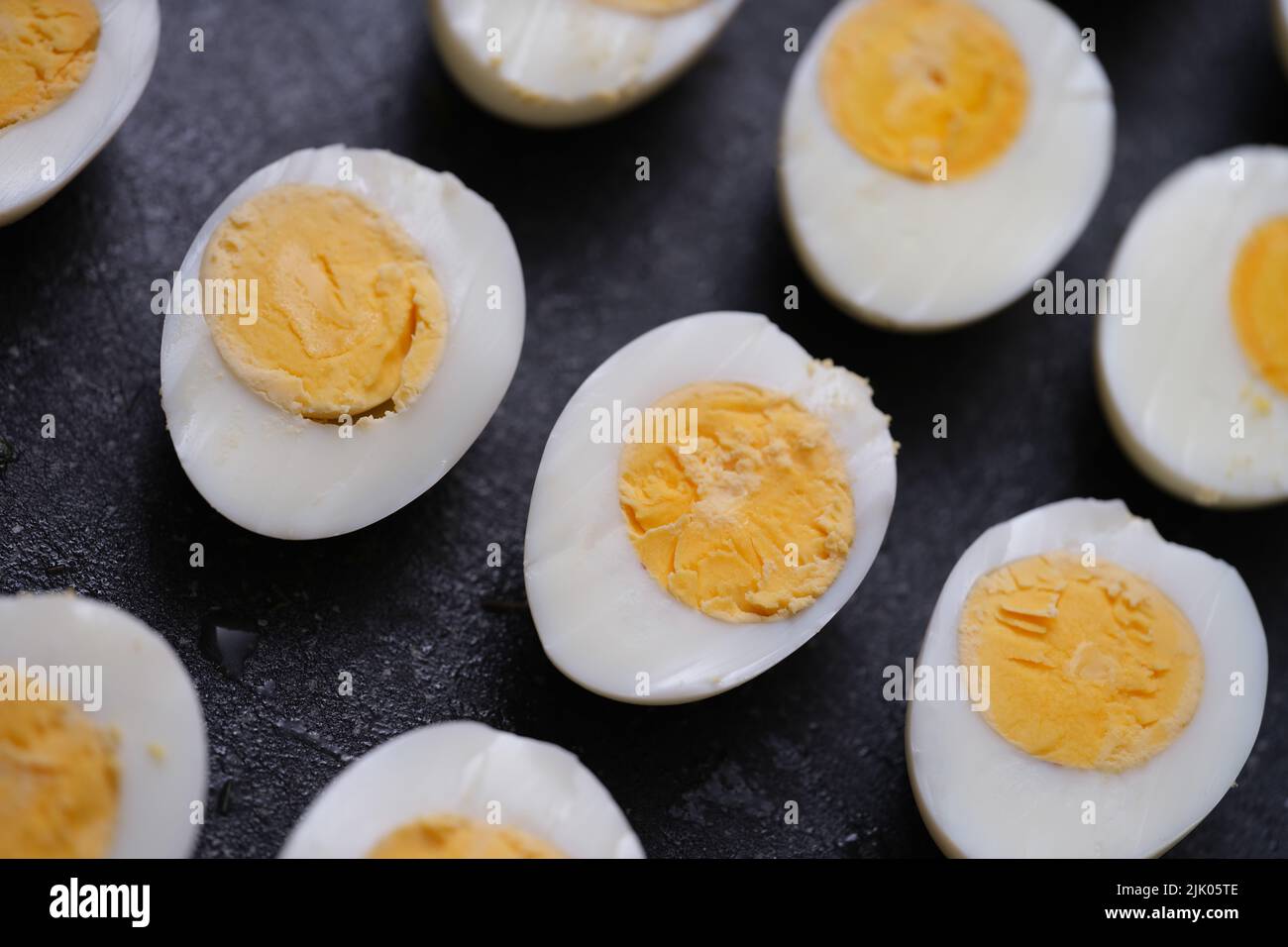 Sliced hard boiled eggs on dark background Stock Photo