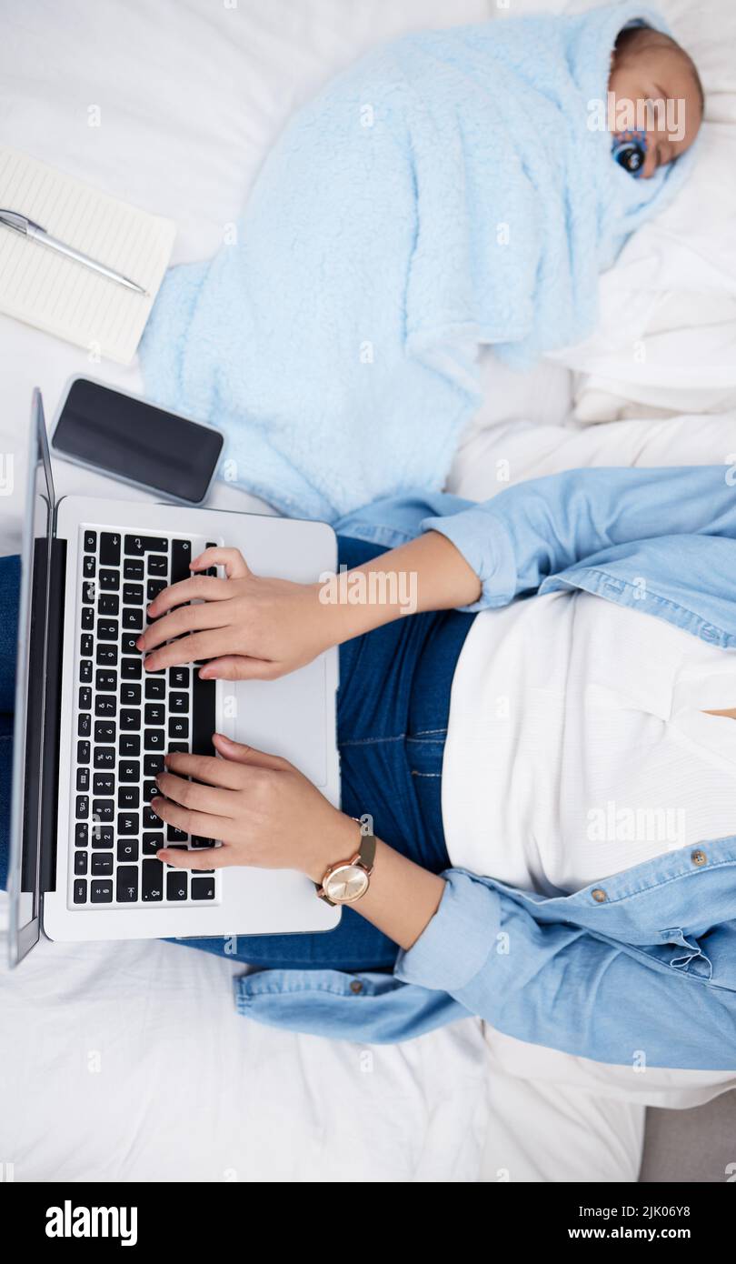 Work and home life balance. a mother using her laptop while her baby