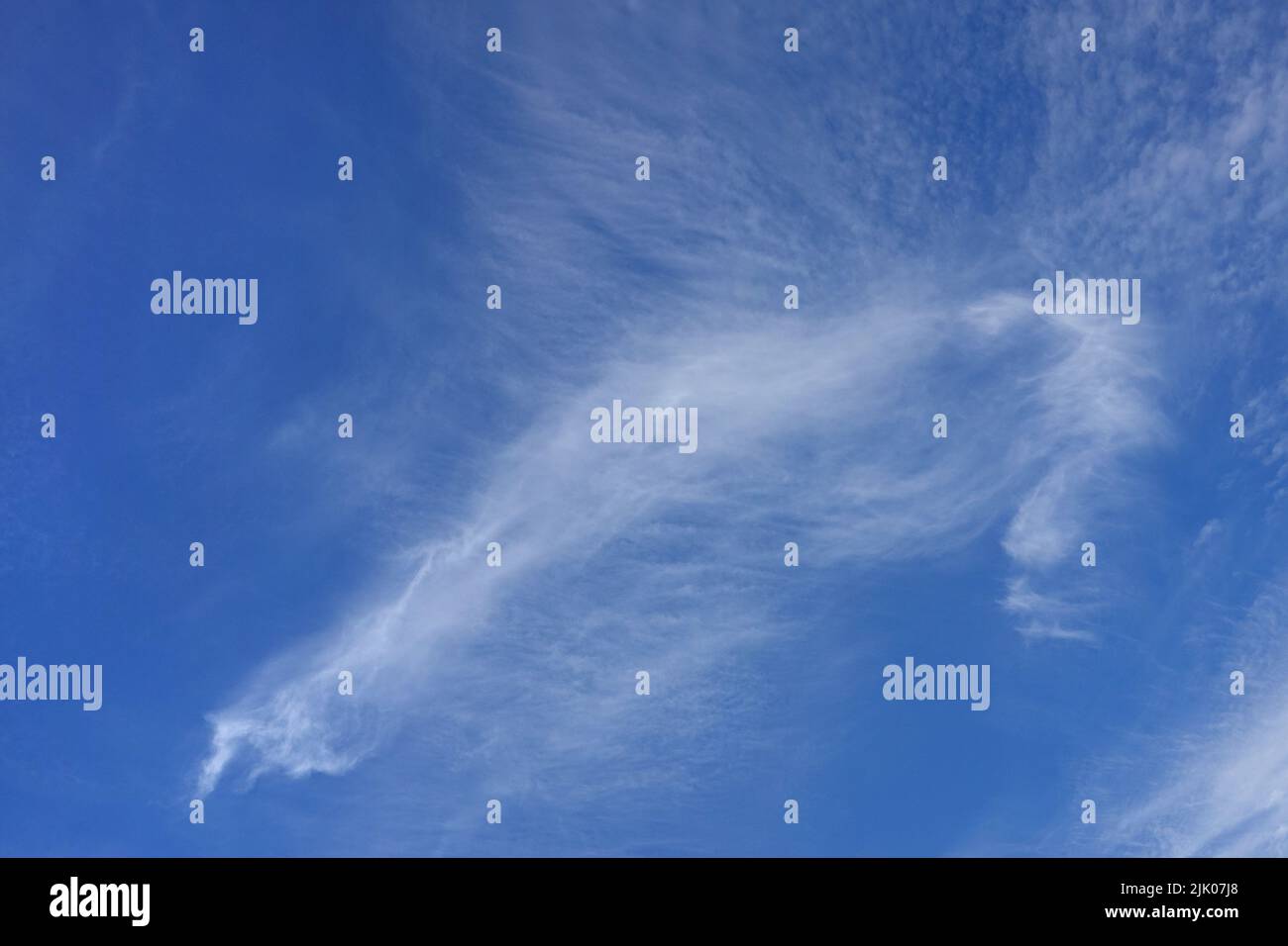 Cirrus clouds in blue sky, thin and wispy, formed by ice crystals at high altitude Stock Photo