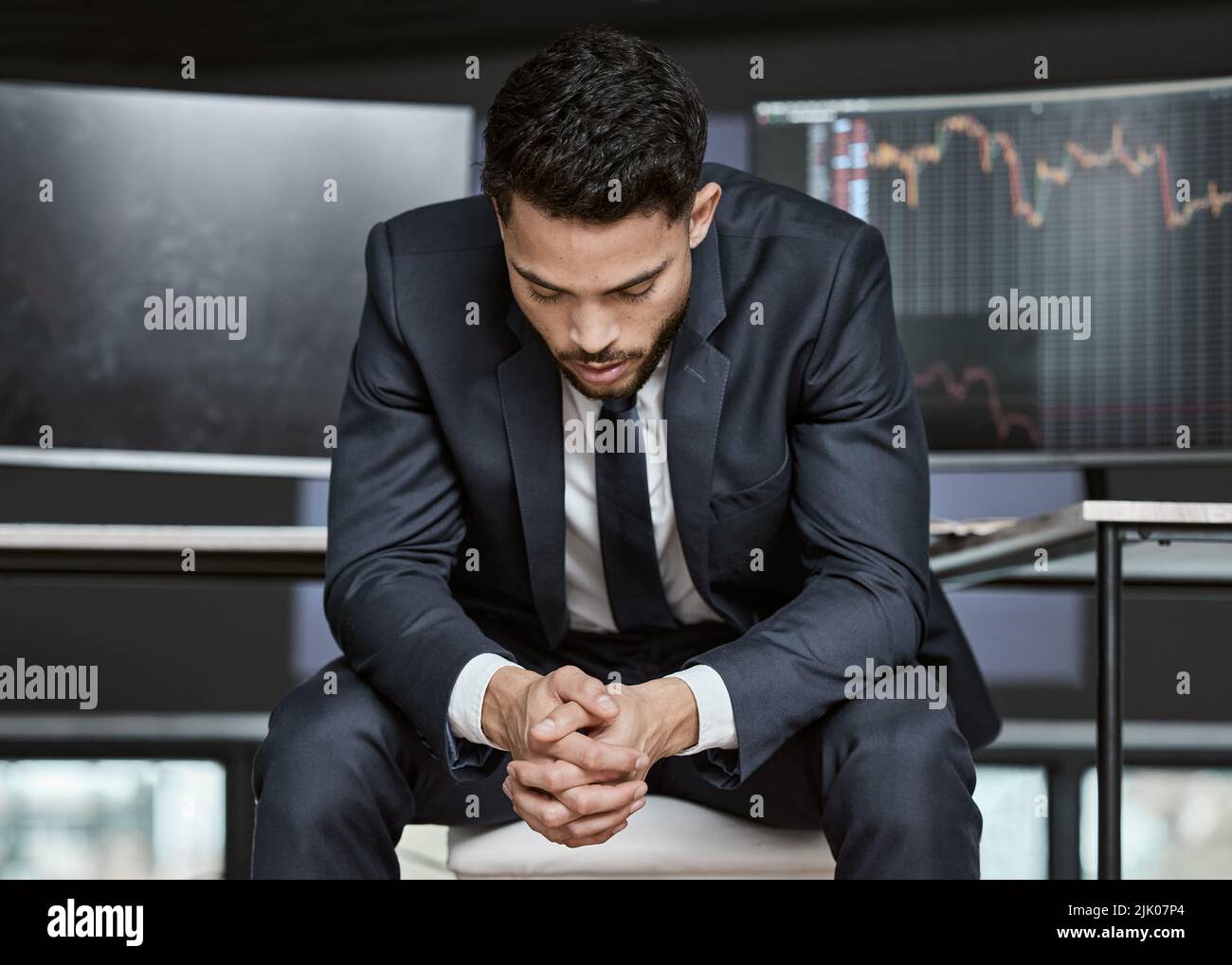 Businessman with depression on the stock market, trading during a financial crisis. Stressed trader in a bear market, looking at stocks crashing Stock Photo