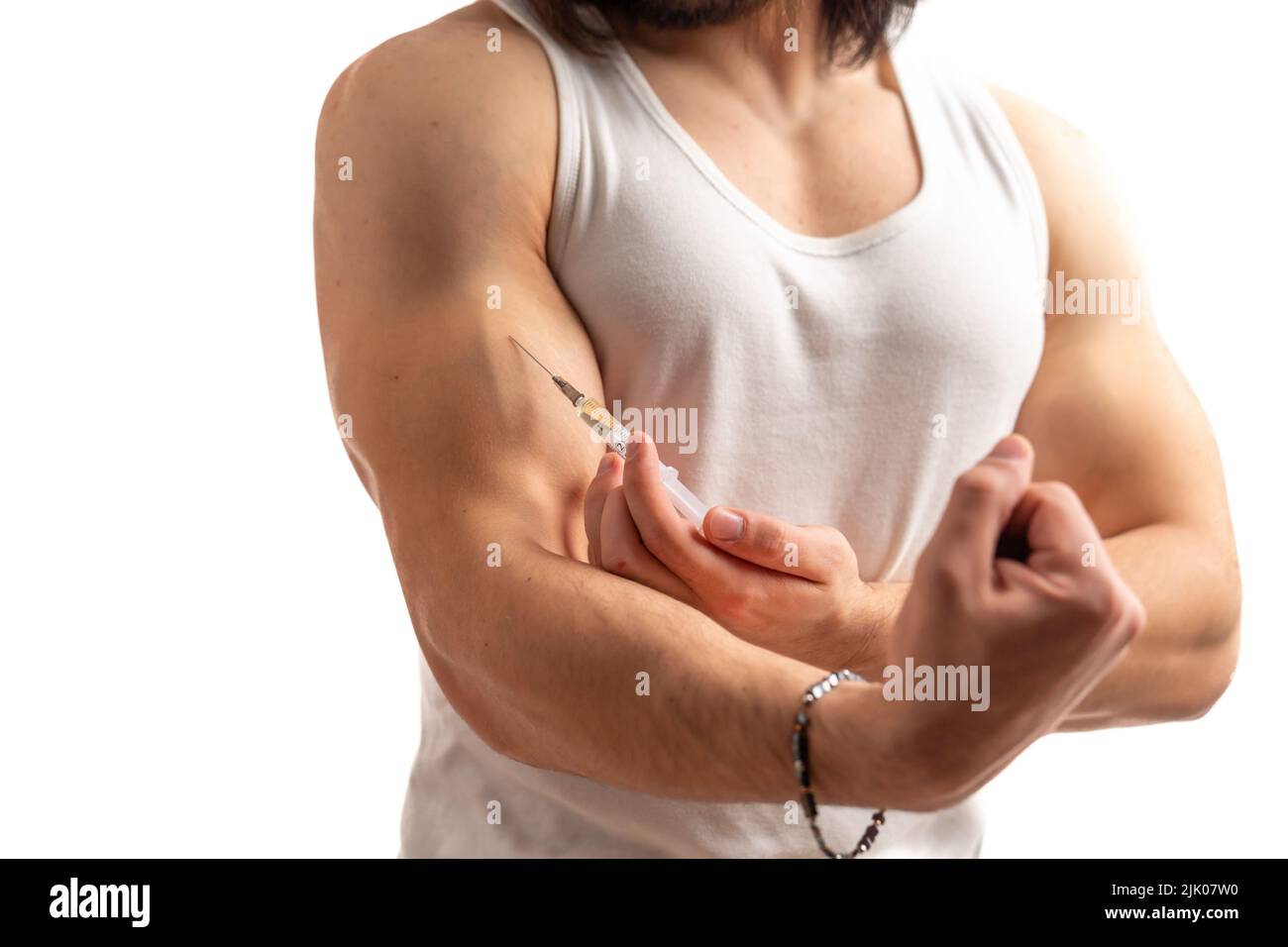 A long haired isolated muscular man taking a jab into muscles. Closeup