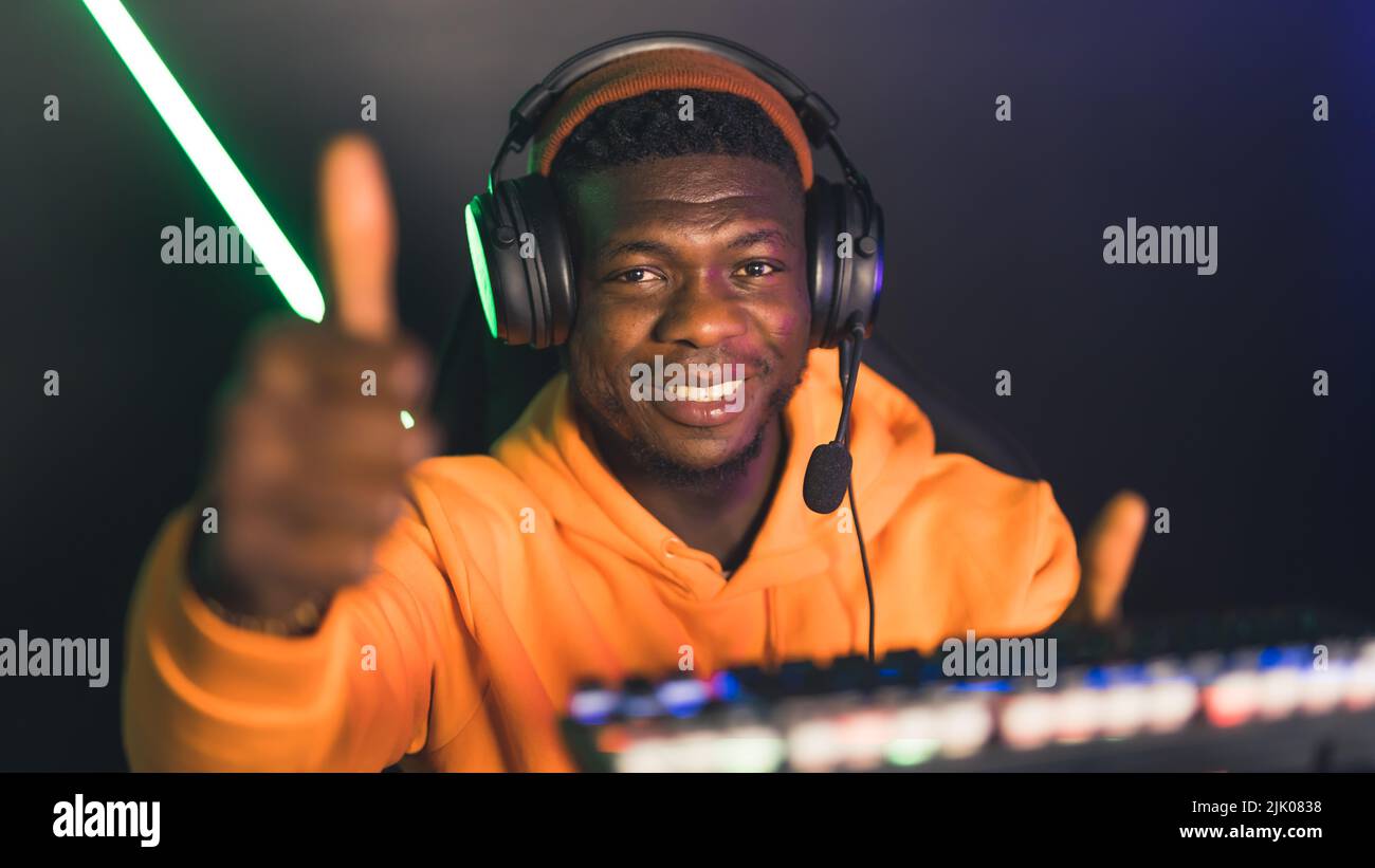 Young black man wearing beanie and headset smiling looking into camera ...
