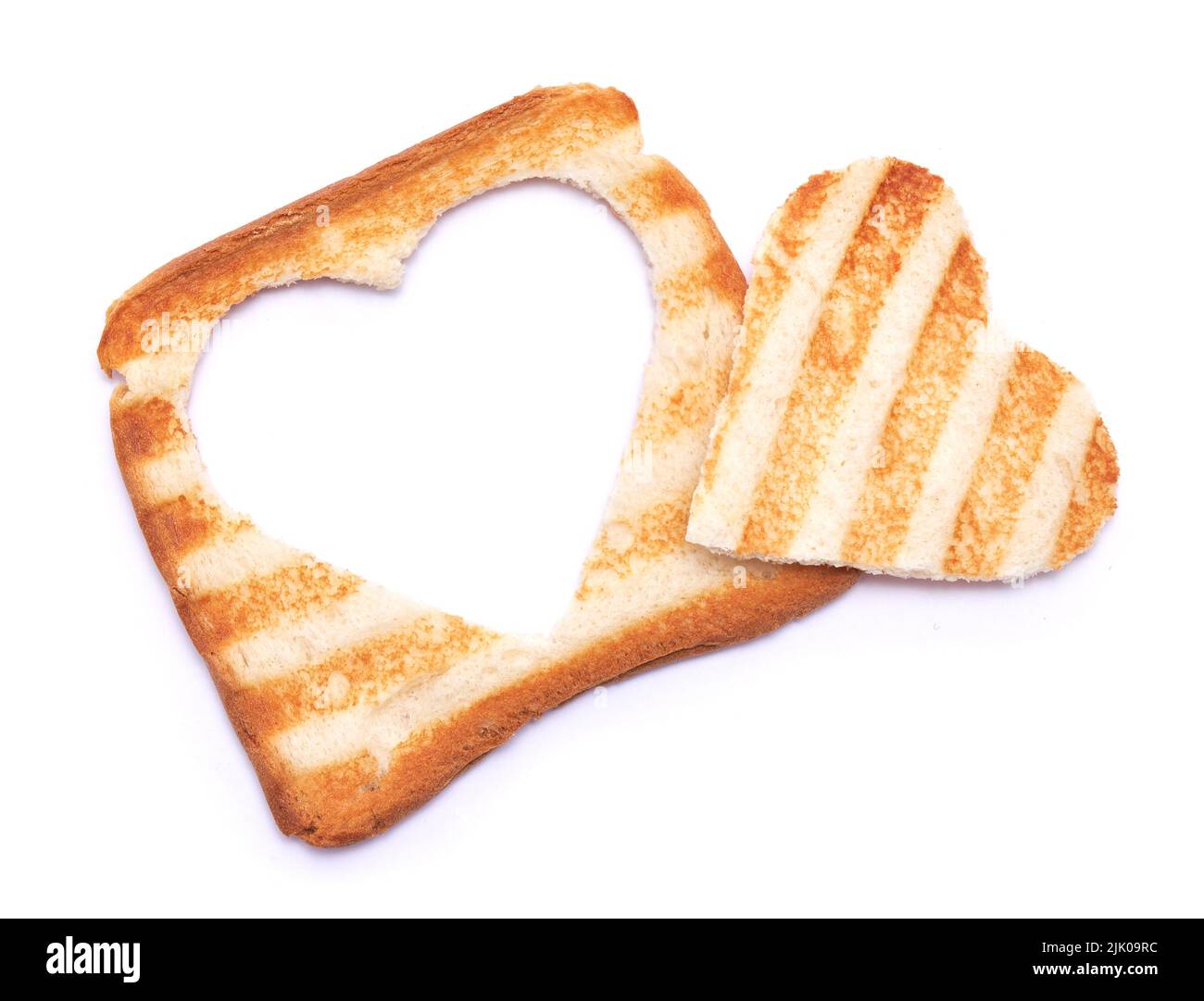 Toasted bread with grill marks and heart shaped hole isolated on white