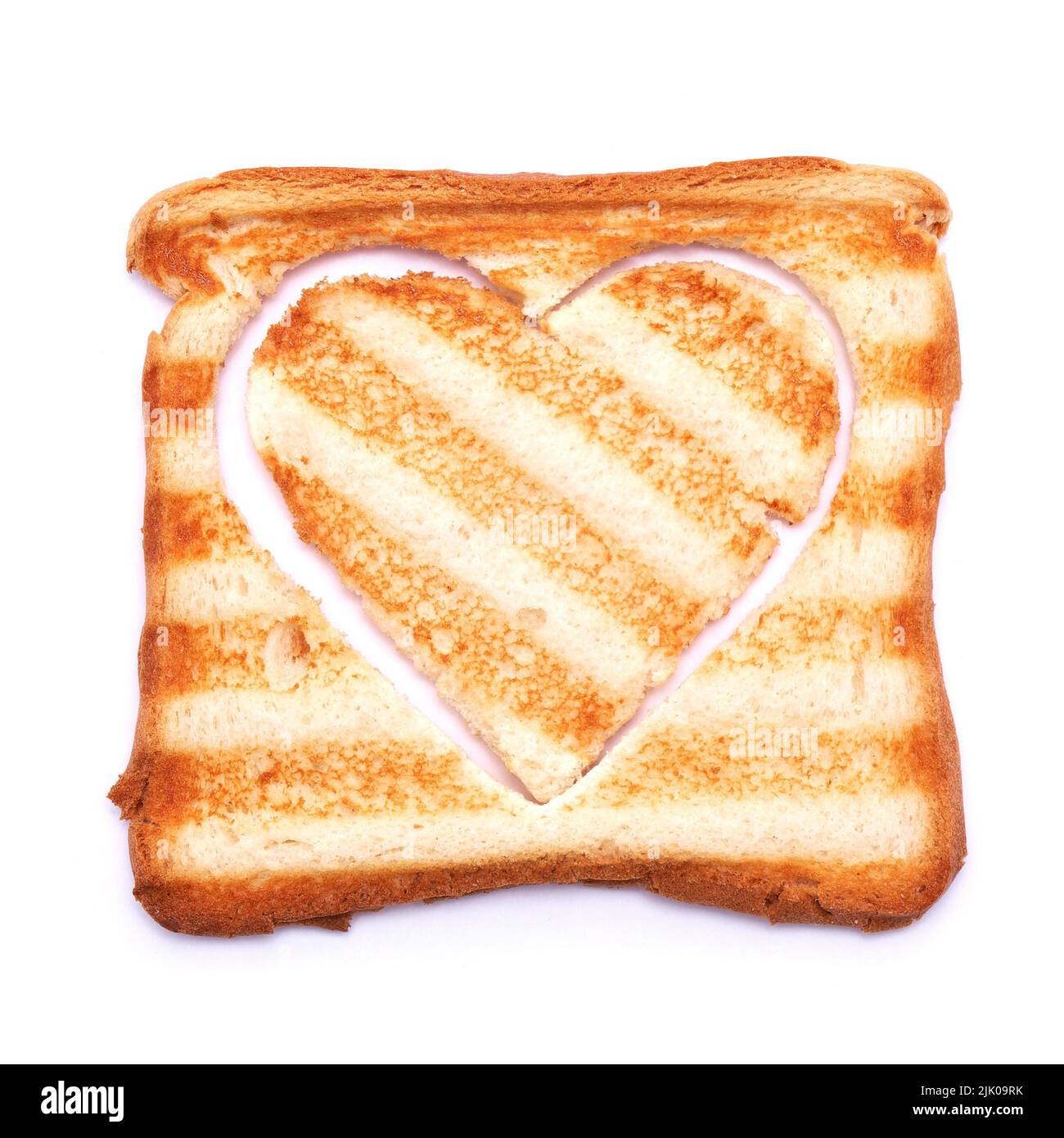 Toasted bread with grill marks and heart shaped hole isolated on white