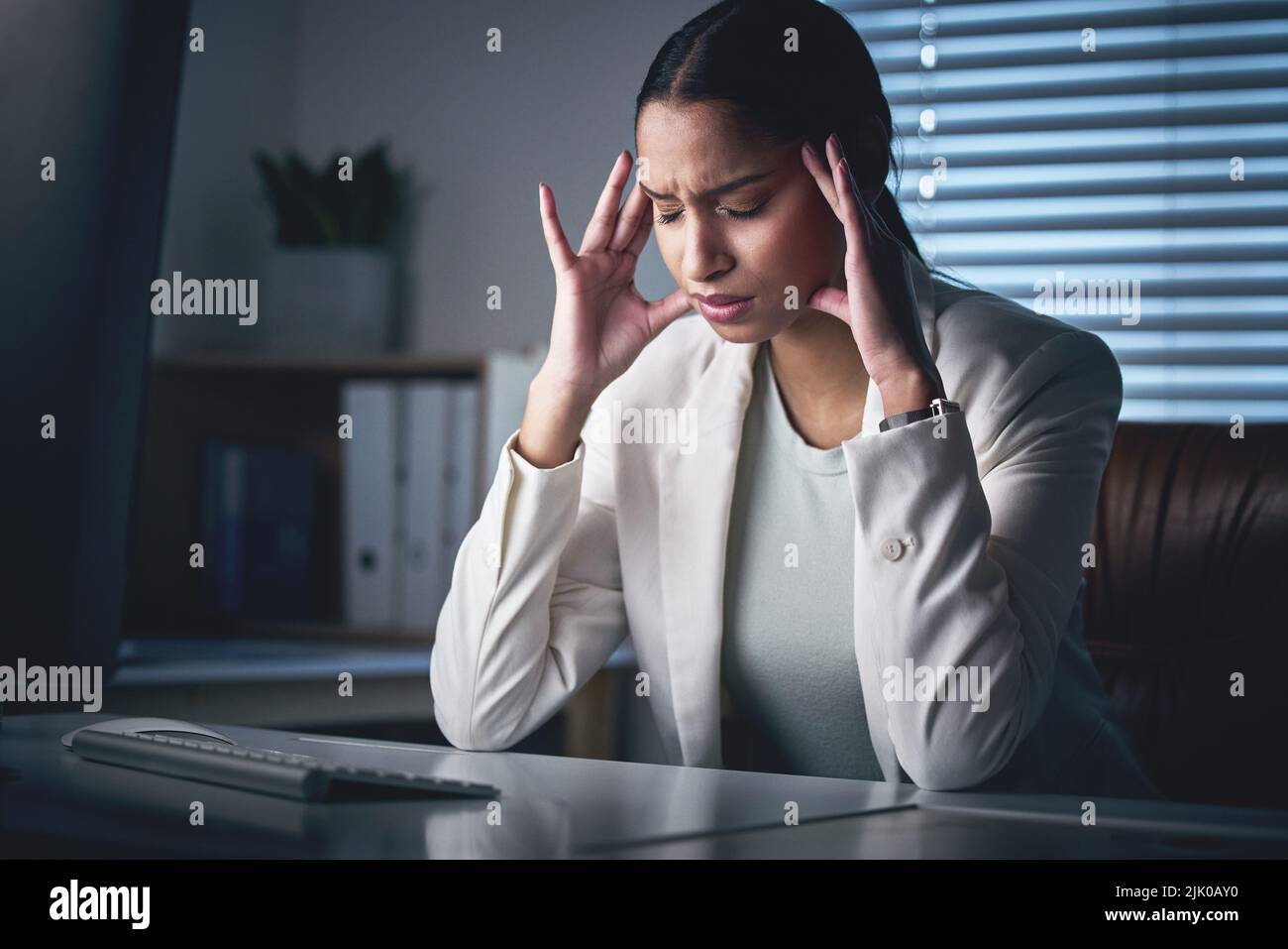 I have a splitting headache. an attractive young businesswoman sitting