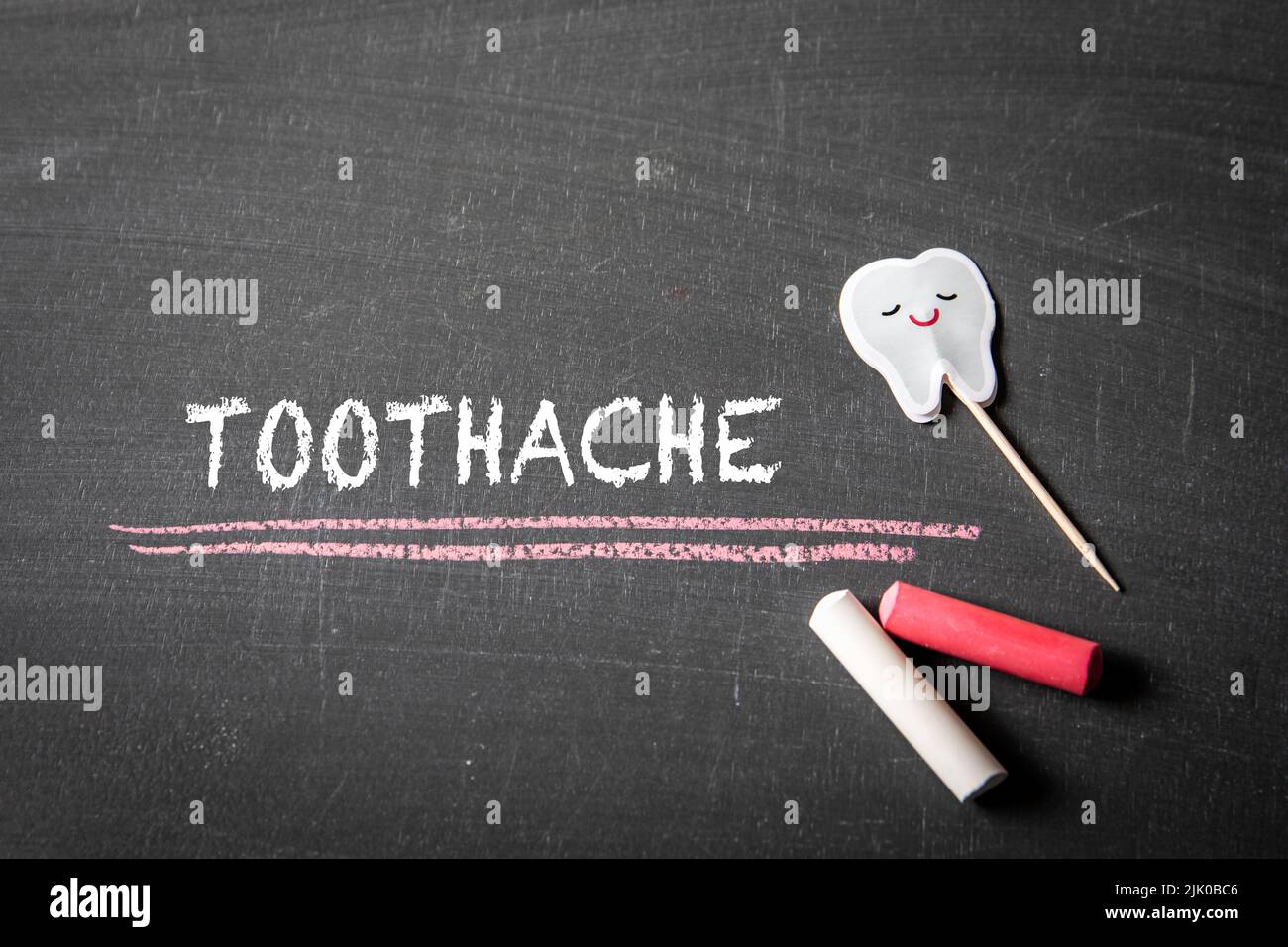Toothache. Text and pieces of chalk on a black chalkboard. Stock Photo