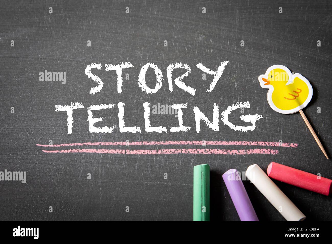 Story Telling. Text and colored pieces of chalk on a blackboard. Stock Photo