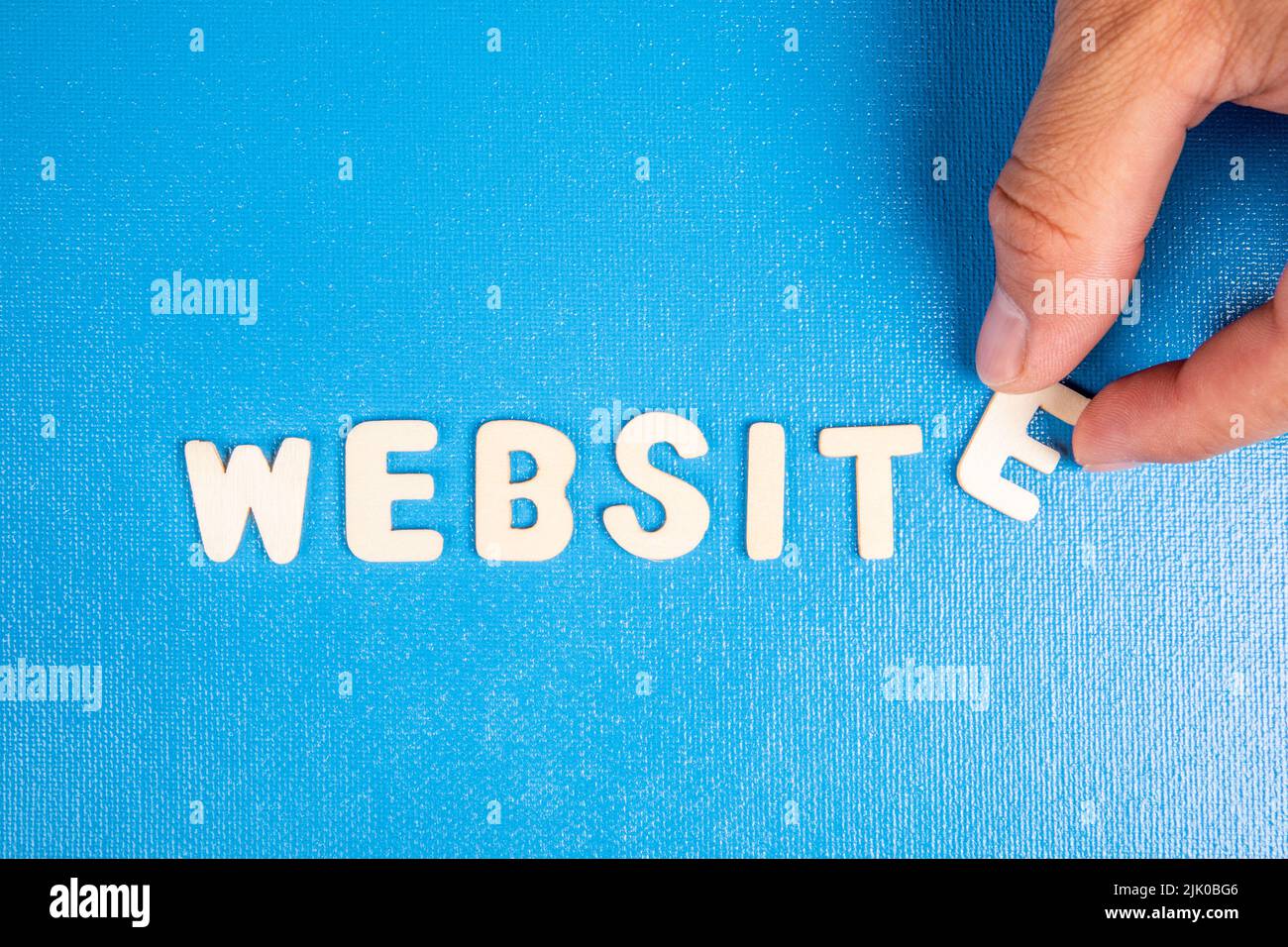 Website. Text from white wooden letters on a blue background. Stock Photo