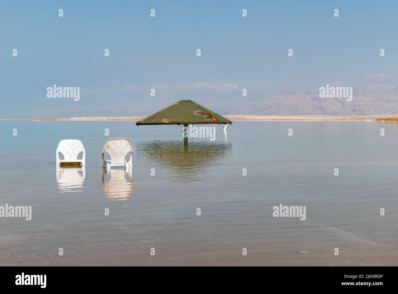 canopy from the sun and two chairs in the water of the dead sea in Israel Stock Photo